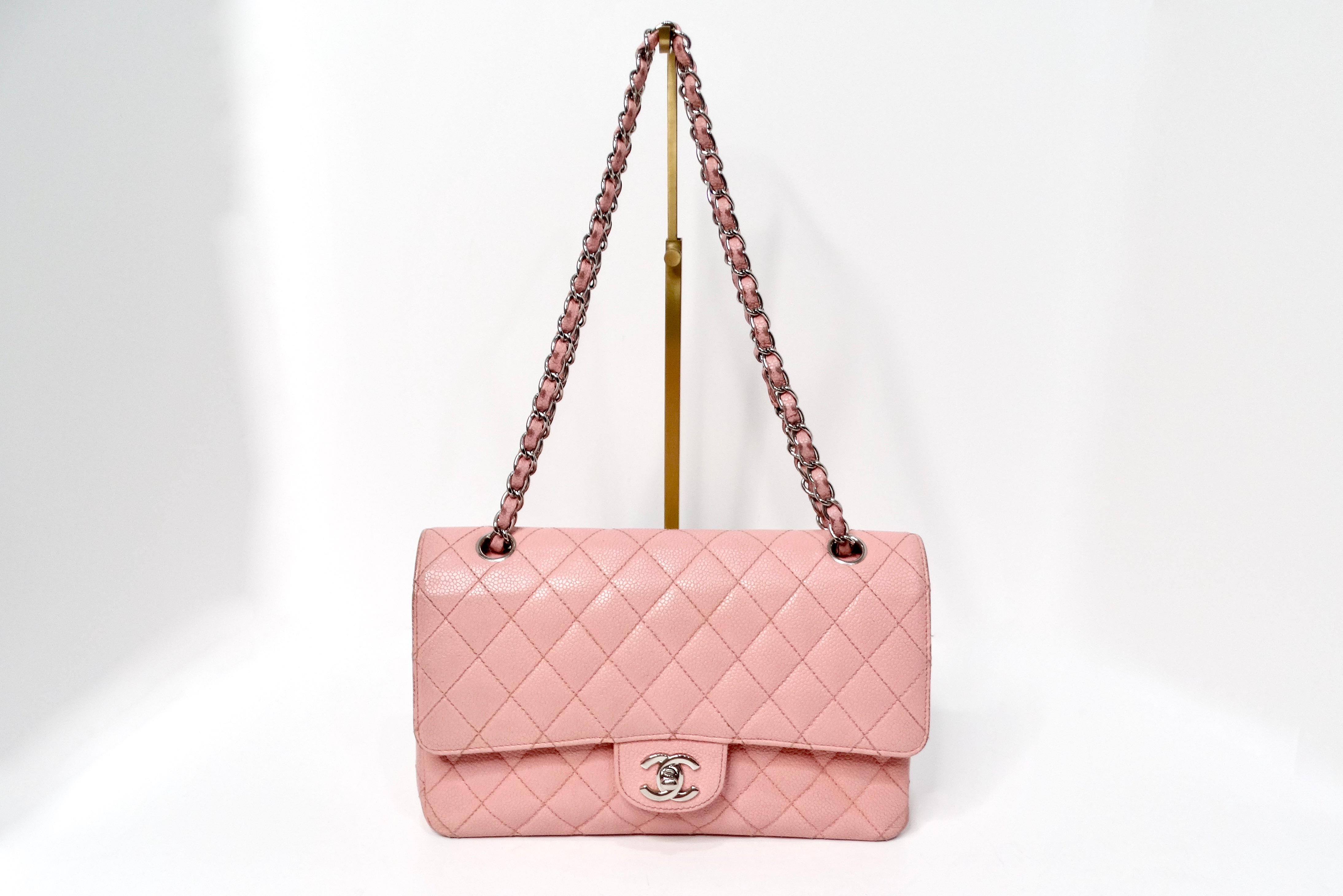 The Chanel 2004 Small Pink Caviar Leather Classic Double-Flap Handbag is a quintessential piece of luxury that exudes femininity and timeless charm. This handbag is crafted from durable caviar leather, adorned in a sweet pink hue that perfectly