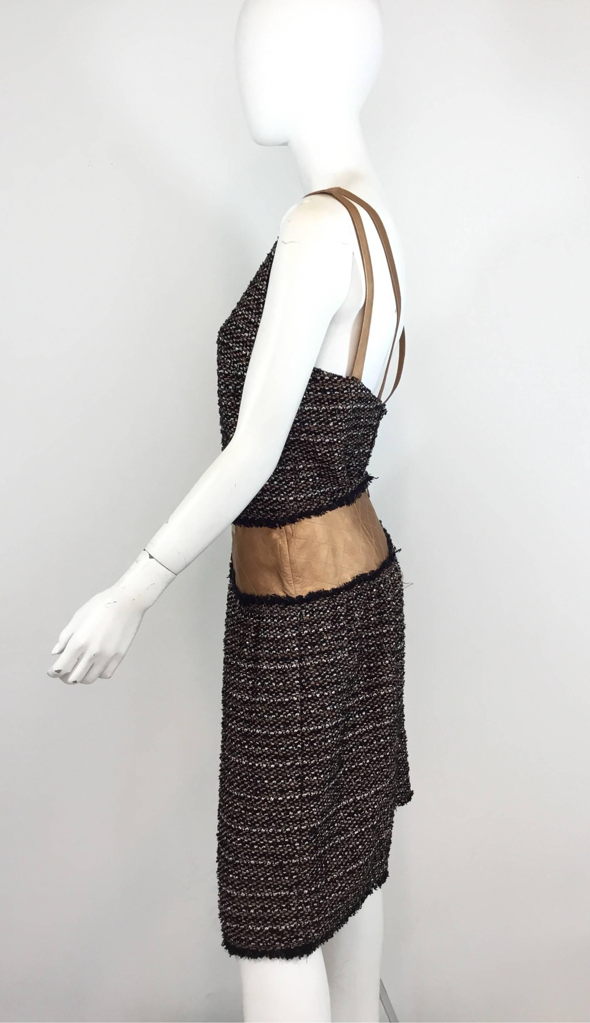 Chanel fantasy tweed skirt set from 2005 A collection. Skirt features a copper metallic leather trimmed waist, back zipper closure, and full lining. Top has a V-neckline, leather straps, back button closures, and full lining. Excellent condition.