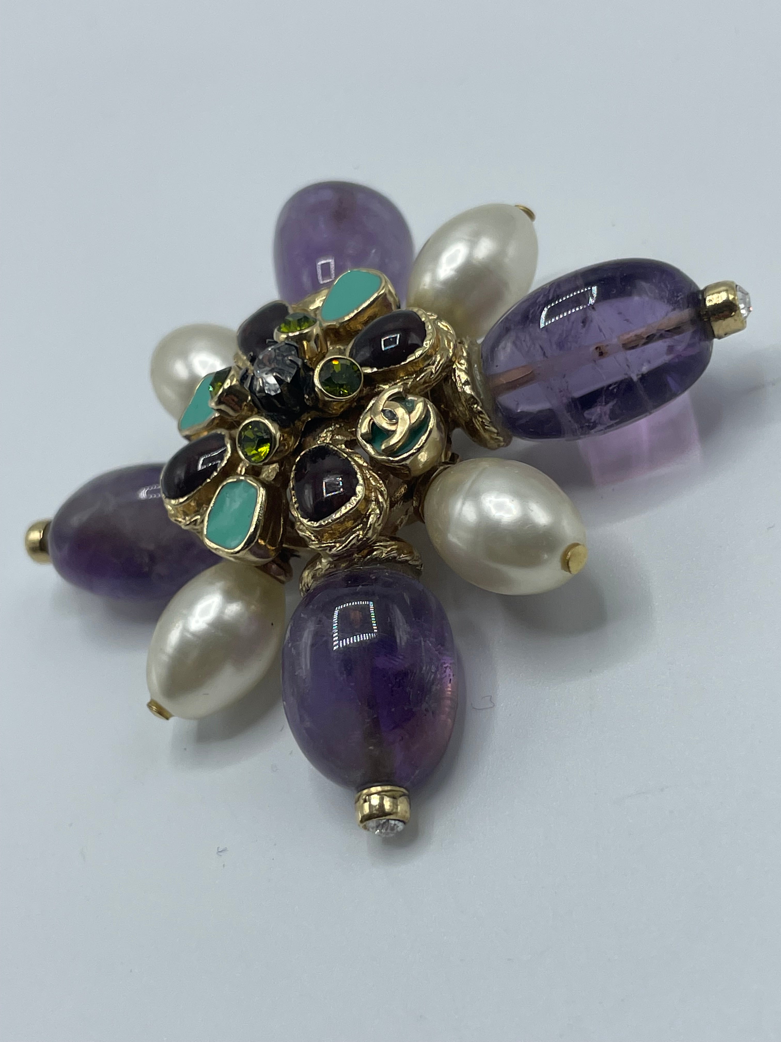 Massive Chanel pin or necklace with four huge, polished, amethyst stones arranged in a starburst or cross arrangement. Gripoix poured glass and crystal stones into the amethyst's core and outermost points. On the back, there is a large CC. It has a