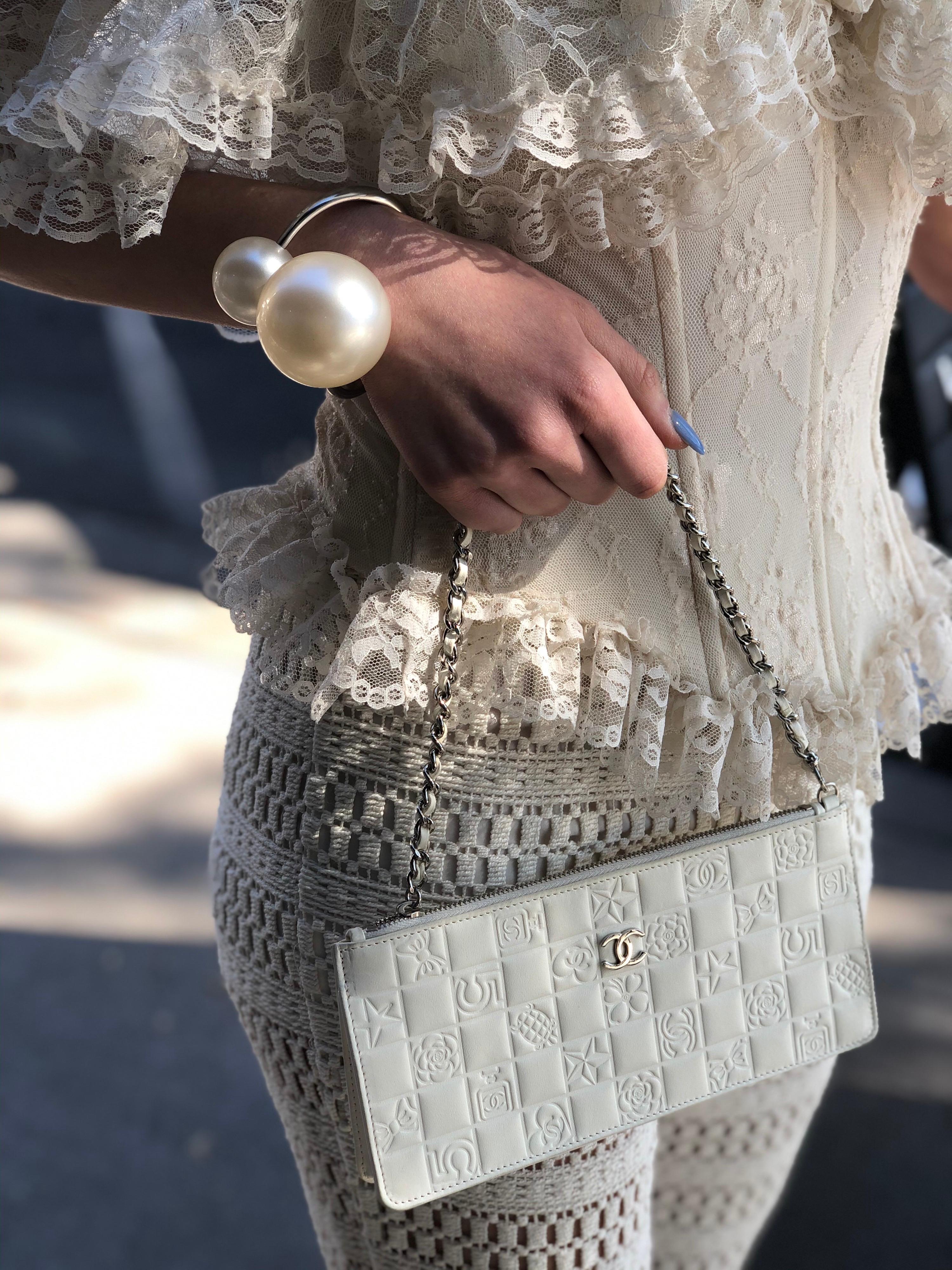 Feel lucky with this adorable Chanel wristlet! Circa 2005 from their Spring collection, this Chanel white wristlet is the perfect addition to any look, dressy or casual. Features a white leather and chain strap, top zipper closure, and is fully