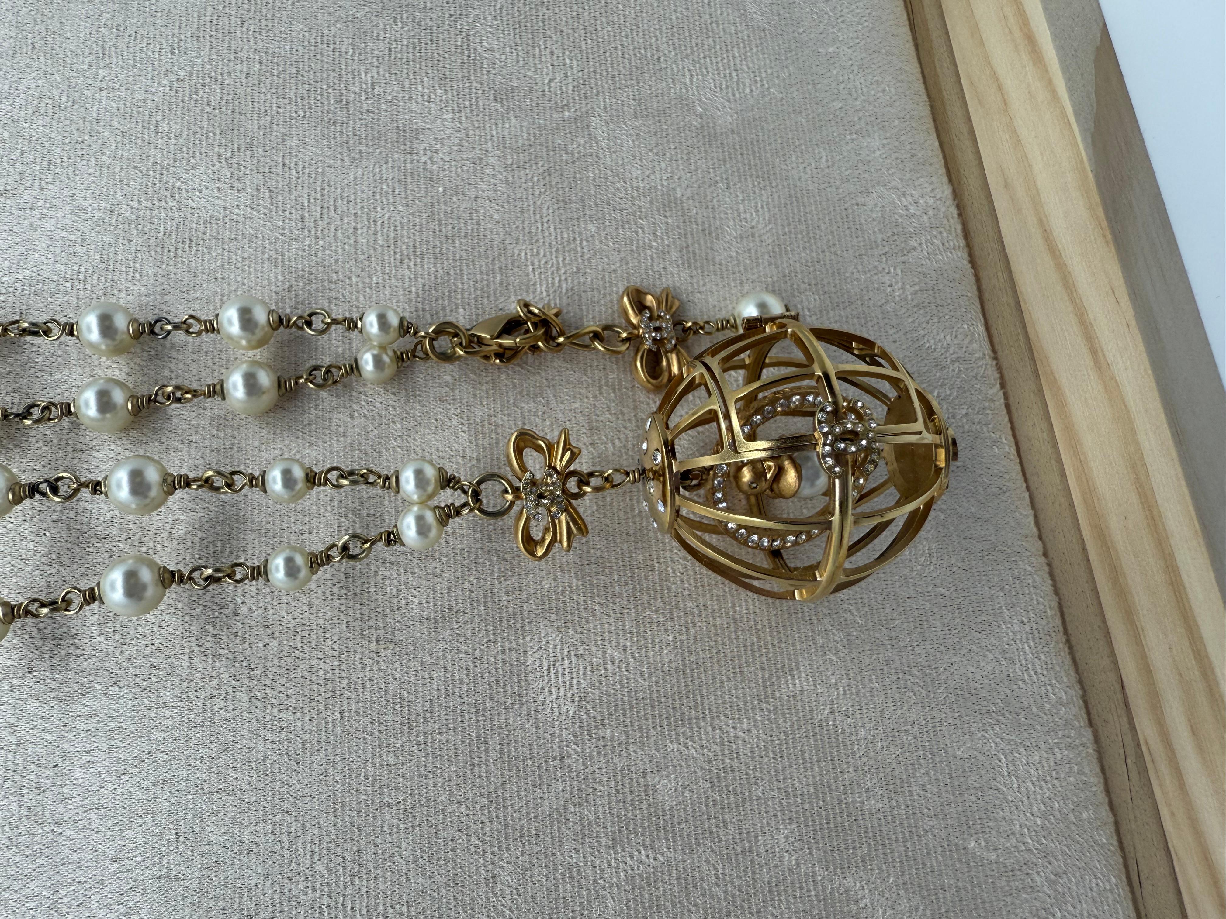 Eine seltene und theatralische Chanel-Halskette aus der Collection'S 2006 mit einem übergroßen goldfarbenen Vogelkäfig-Anhänger mit einem schwebenden CC-Logo und einer Perle in der Mitte. Der mit Brillianten verzierte Anhänger erinnert an