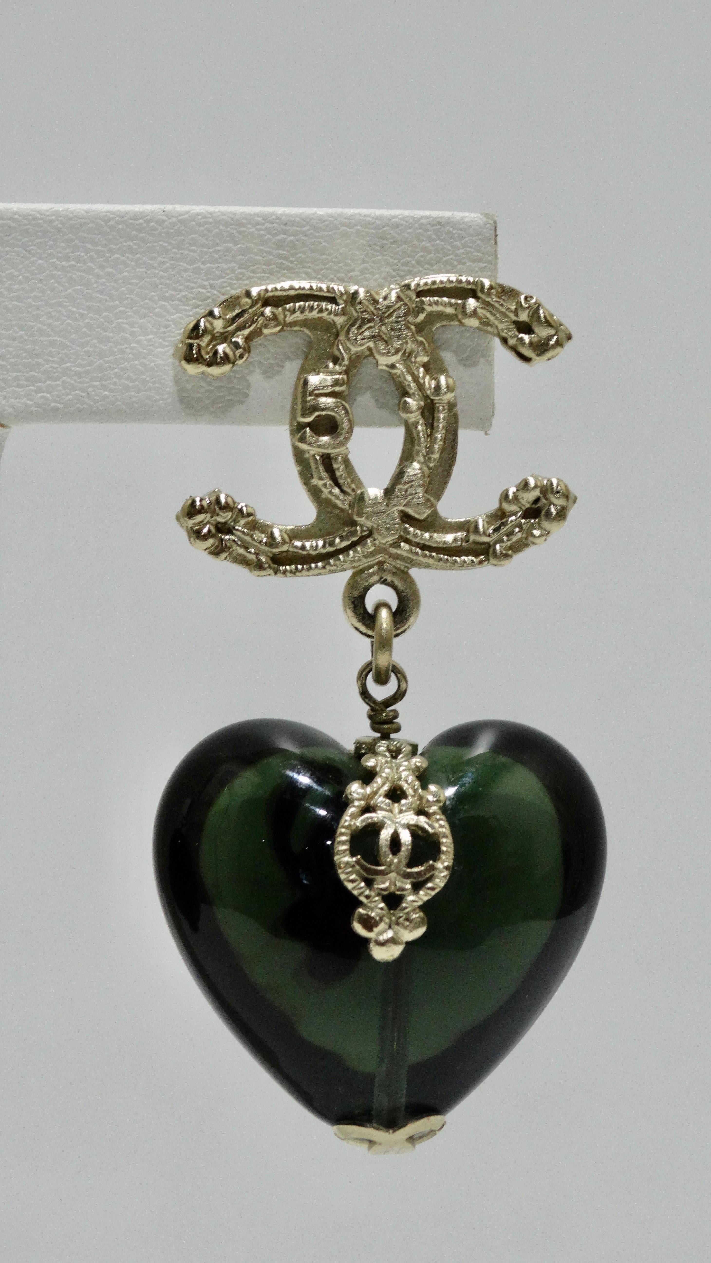 For the ultimate Chanel lover! Circa 2006 from their fall/winter collection, these earrings feature a green tone resin heart hanging from a large CC that is decorated with symbols unique to Coco; the four leaf clover, no. 5, bows and of course the