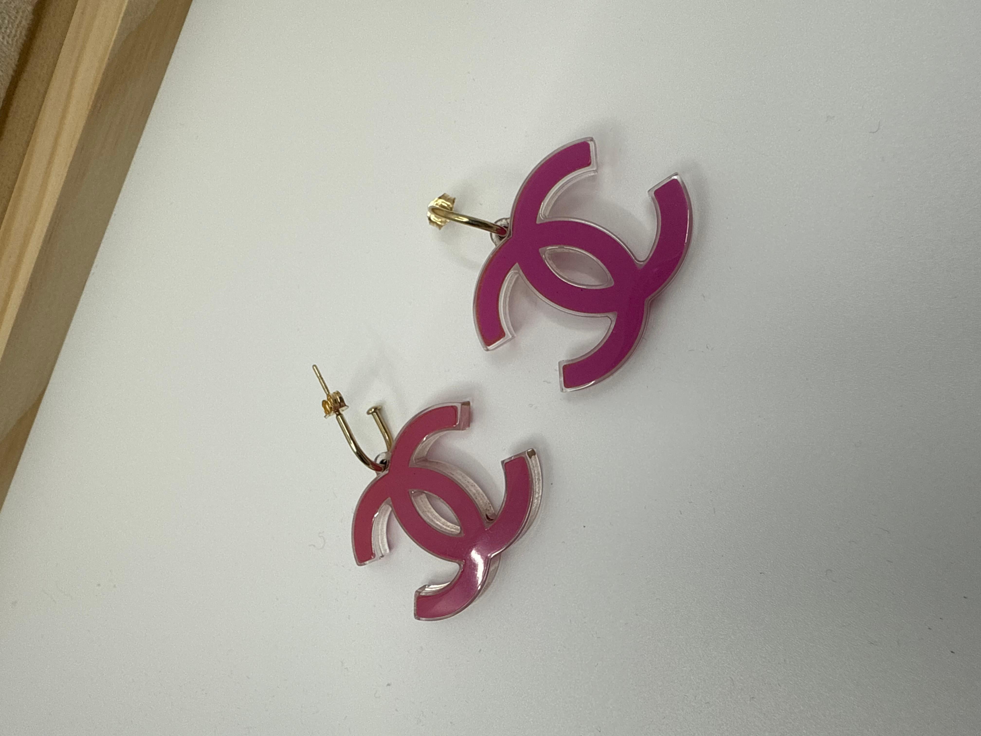 Aggiungi un tocco di rosa alla tua collezione con questi iconici orecchini con logo Chanel CC della primavera 2007. Realizzato in lucite rosa Barbie con un bordo trasparente, questo paio di scarpe di grande effetto incarna lo spirito divertente e