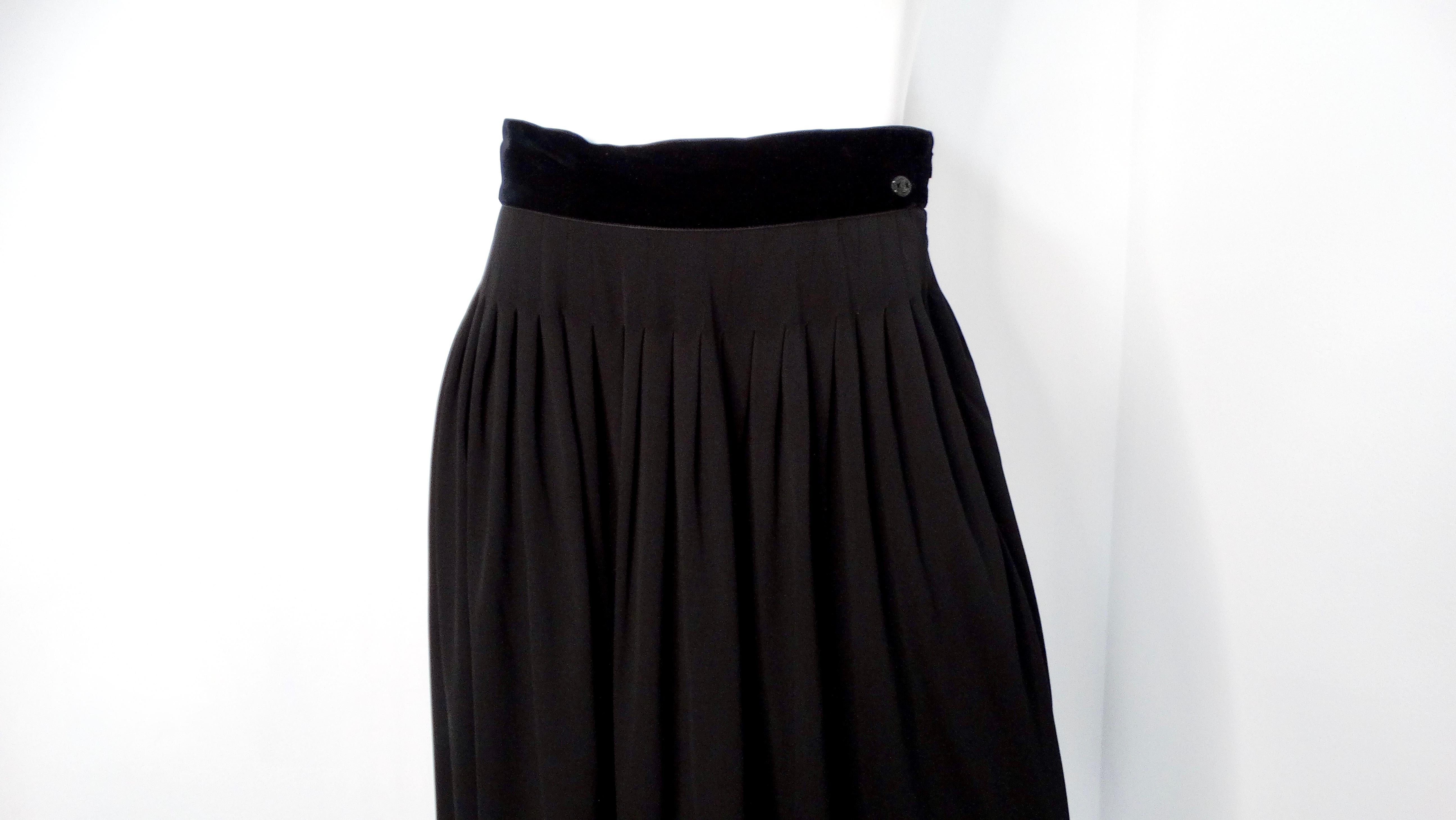 La gonna a pieghe nera Chanel 2007 è l'epitome dell'eleganza e della versatilità senza tempo. Questa maxi gonna chic è caratterizzata da un colore nero monocromatico che la rende un capo essenziale che eleva senza sforzo qualsiasi guardaroba. I