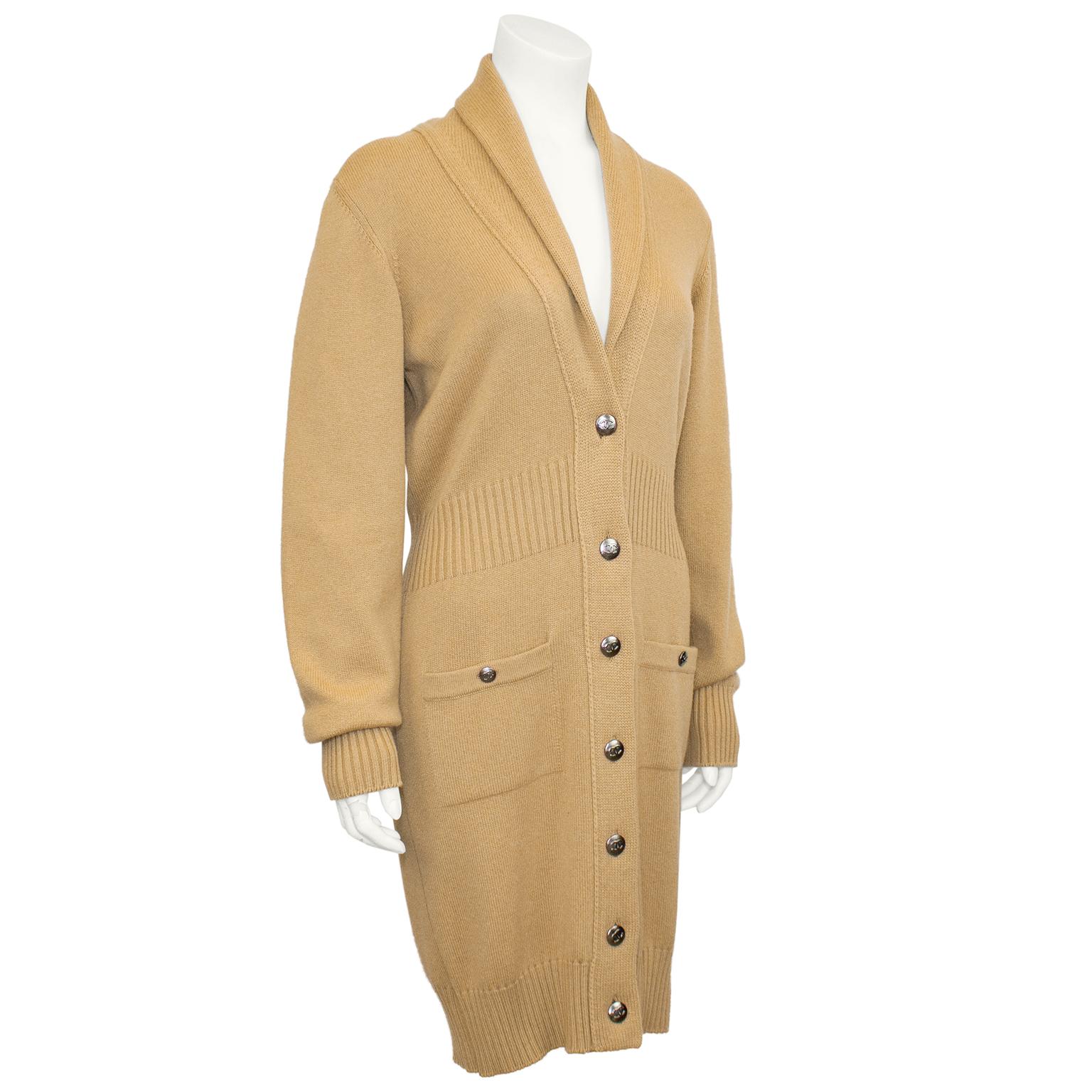 Stunning 2008 Fall/Winter camel color cashmere car coat/long cardigan with shawl collar, patch pockets and self tie belt. The cutest black appliqué Chanel jacket detail sewn on the back of the collar adds a touch of whimsy. In excellent condition,