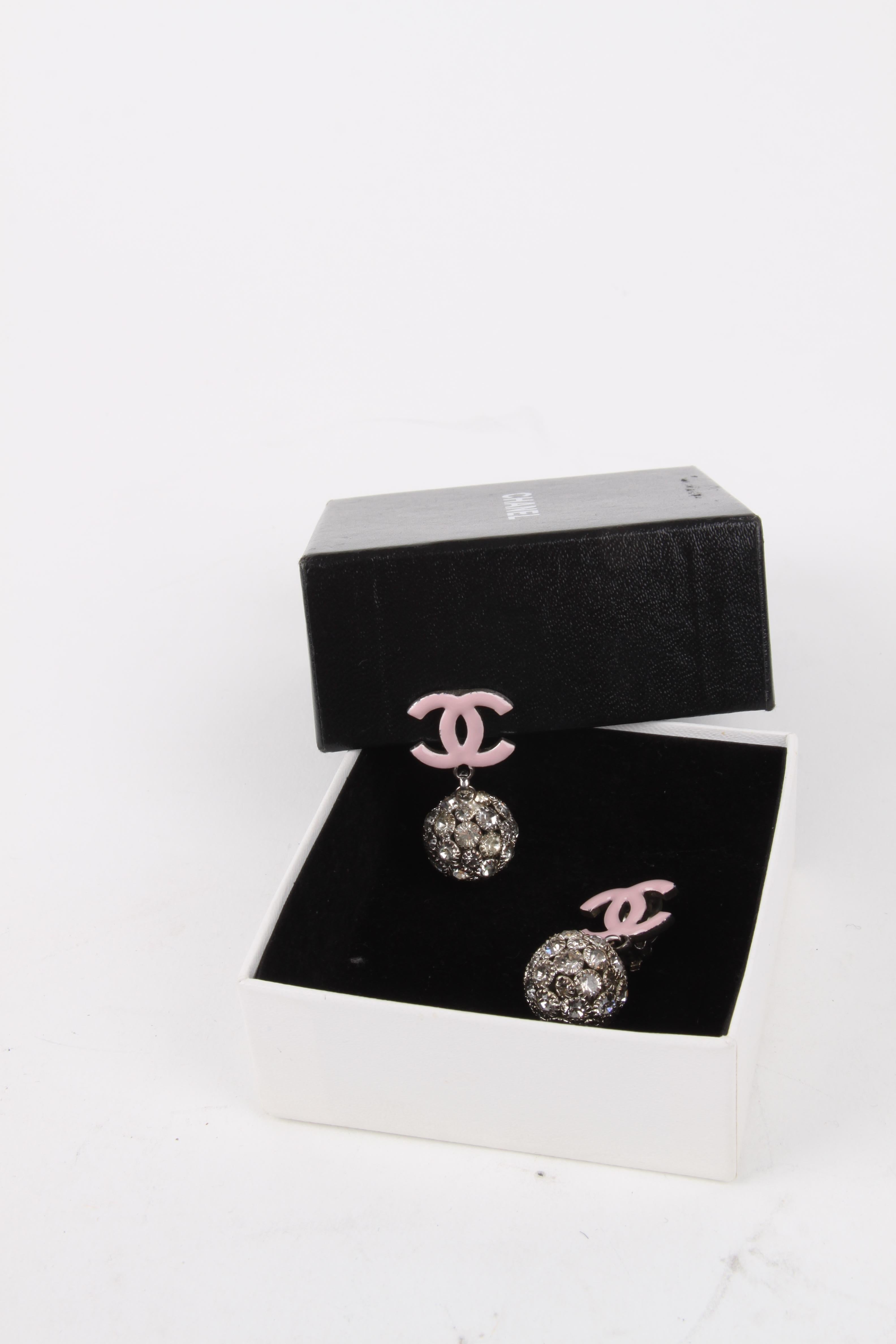 Chanel 2008 Cruise Collection (08C) Pastel Pink Logo Silver Rhinestone Crystal Embellished Ball Clip-On Earrings.

These earrings feature a lux crystal embellished ball exterior with a pink enamel CC-logo embellished finish. The earrings feature a