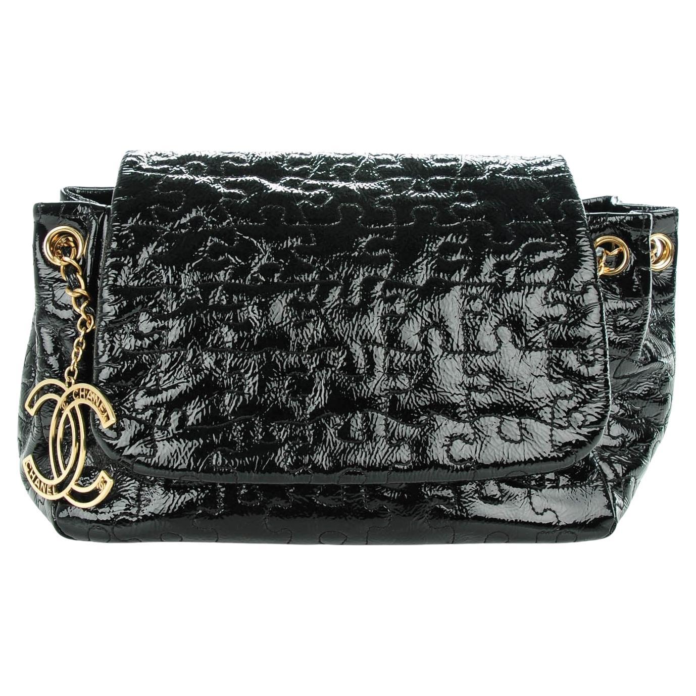 Chanel 2008 Vintage Edición Limitada Bolso de hombro con solapa de rompecabezas de charol 

Año: 2008 

Herrajes dorados
Piel de puzzle acolchada de charol negro
Correa clásica entretejida
Logotipo Chanel CC Charm
Cierre con solapa 
Forro interior