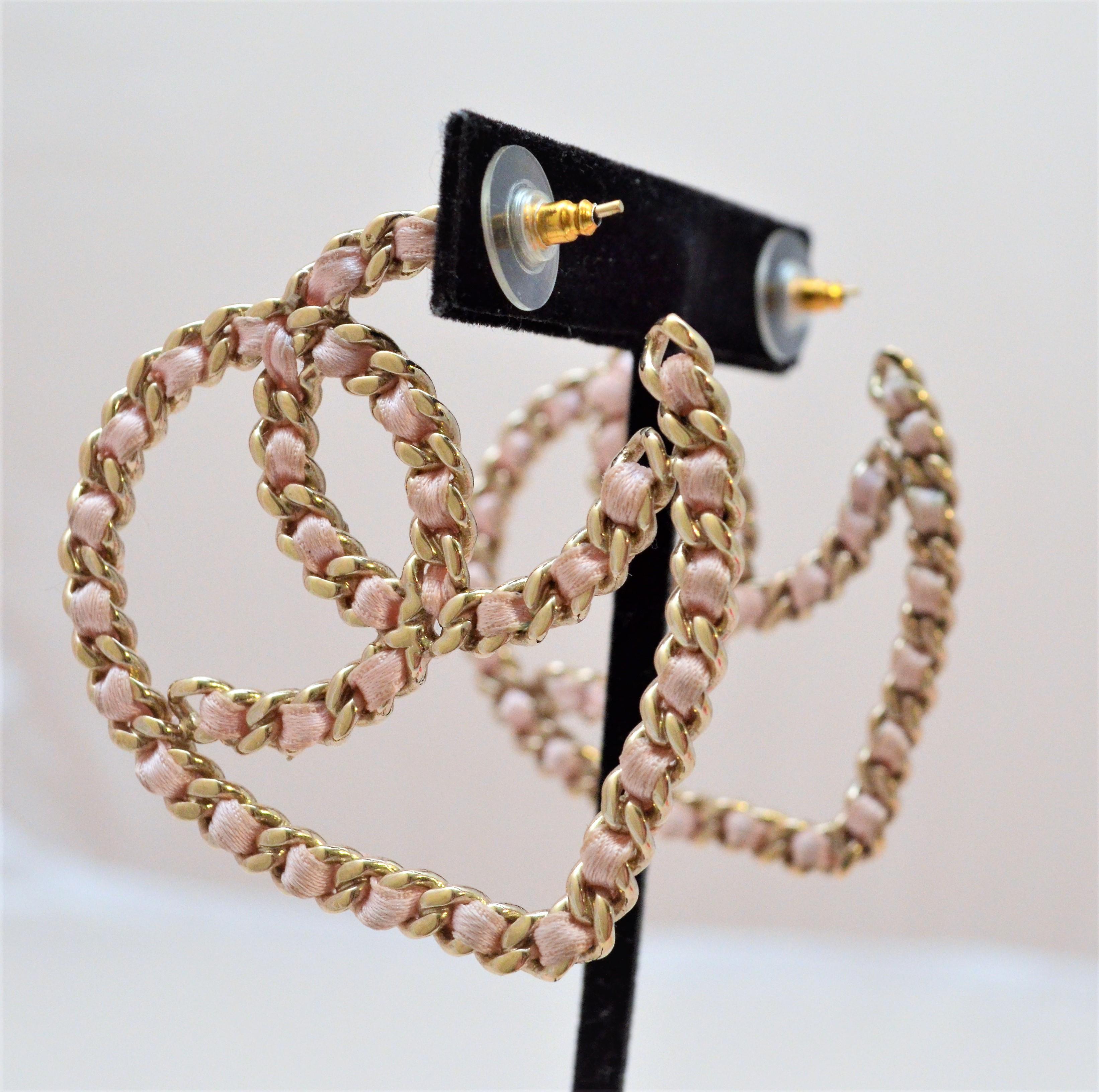 CHANEL Satin Ribbon CC Heart Chain Earrings in pink. Earrings are featured in a champagne-tone metal chain threaded with a satin ribbon creating a Chanel CC logo all in the form of a heart. Earrings are stamped 09 C (2009 Cruise Collection) 