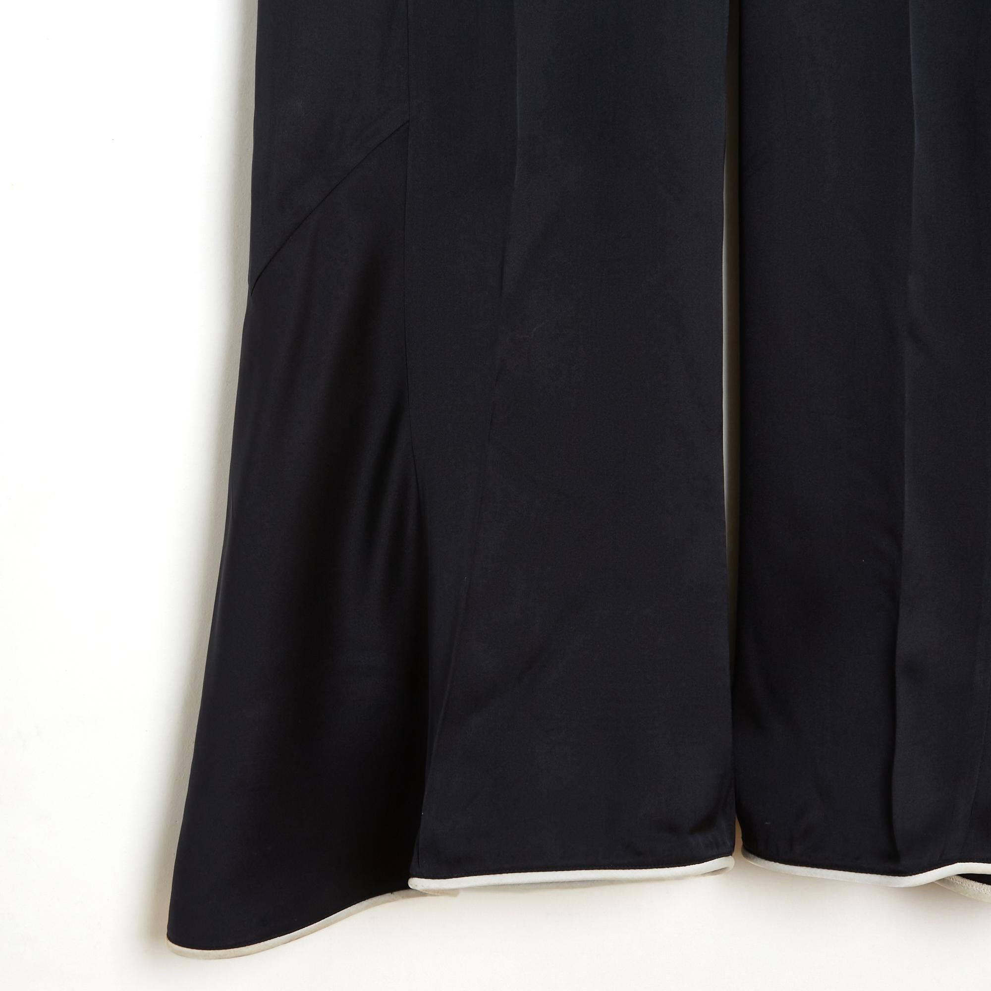 Pantalón de la colección Crucero 2009 de Chanel por Karl Lagerfeld, pernera extra ancha estilo Palazzo, de satén de seda negro ribeteado con ribetes de seda crudo en la cintura y el bajo del pantalón, cintura baja cerrada con cremallera y corchete,