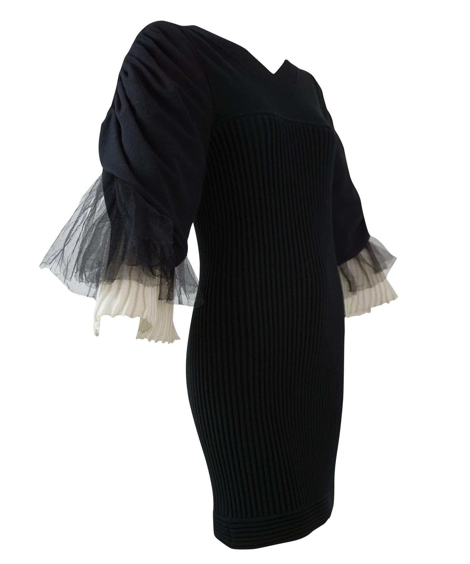 Chanel Schwarzes und cremefarbenes geripptes Kleid. Mit gerüschten Ärmeln aus schwarzem Tüll und weißem Plisseestrick, Bodycon-Mieder aus Rippstrick, Rundhalsausschnitt und CC-Perlen-Reißverschluss am Rücken. Aus der Kollektion Frühjahr 2009.