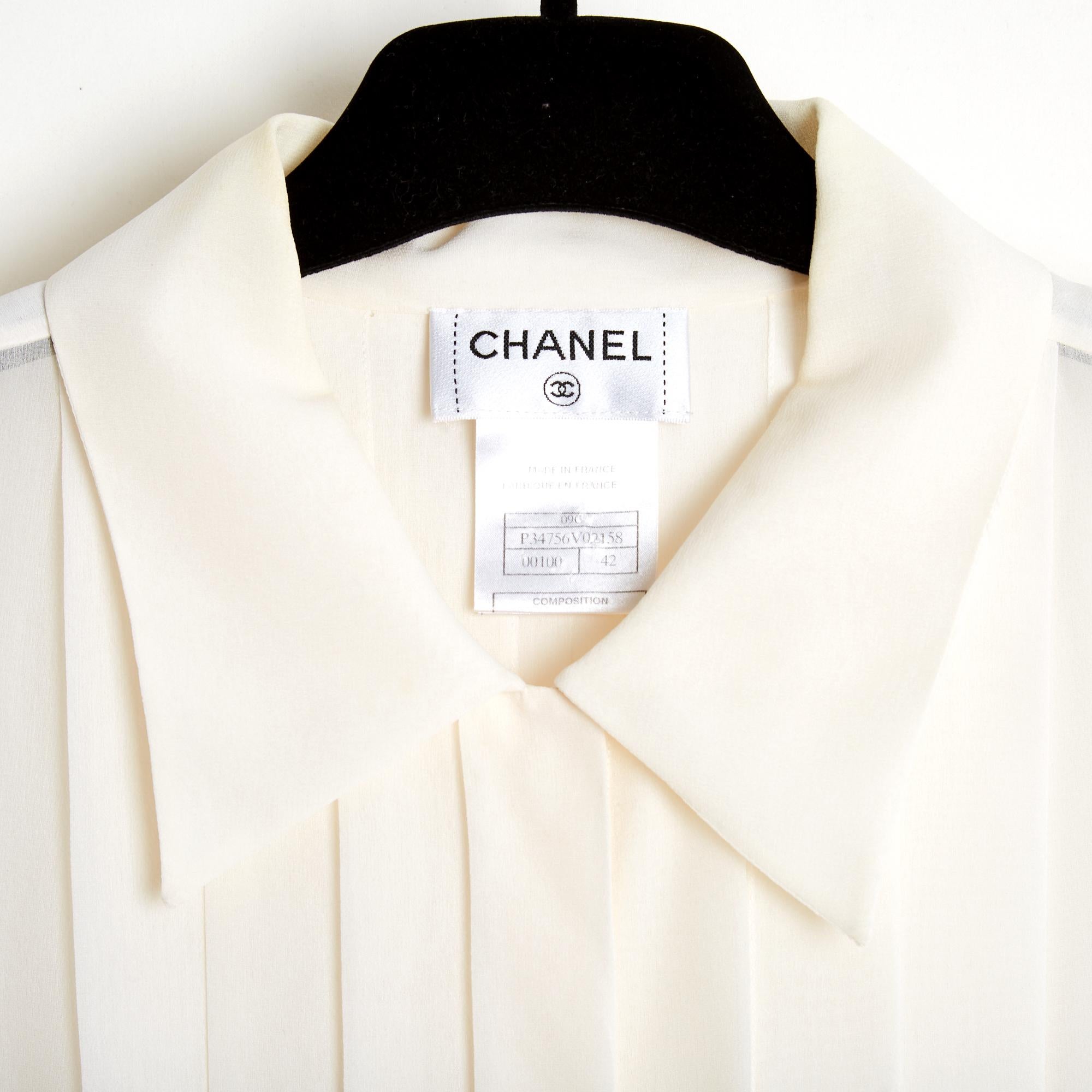 Chanel blouse from the 2009 Cruise or Resort collection (Paris Miami) in ecru silk crepe, sleeveless, shirt collar closed by 6 hidden buttons, in white mother-of-pearl with Chanel logo, pleated bib front and back, small CC logo embroidered on the