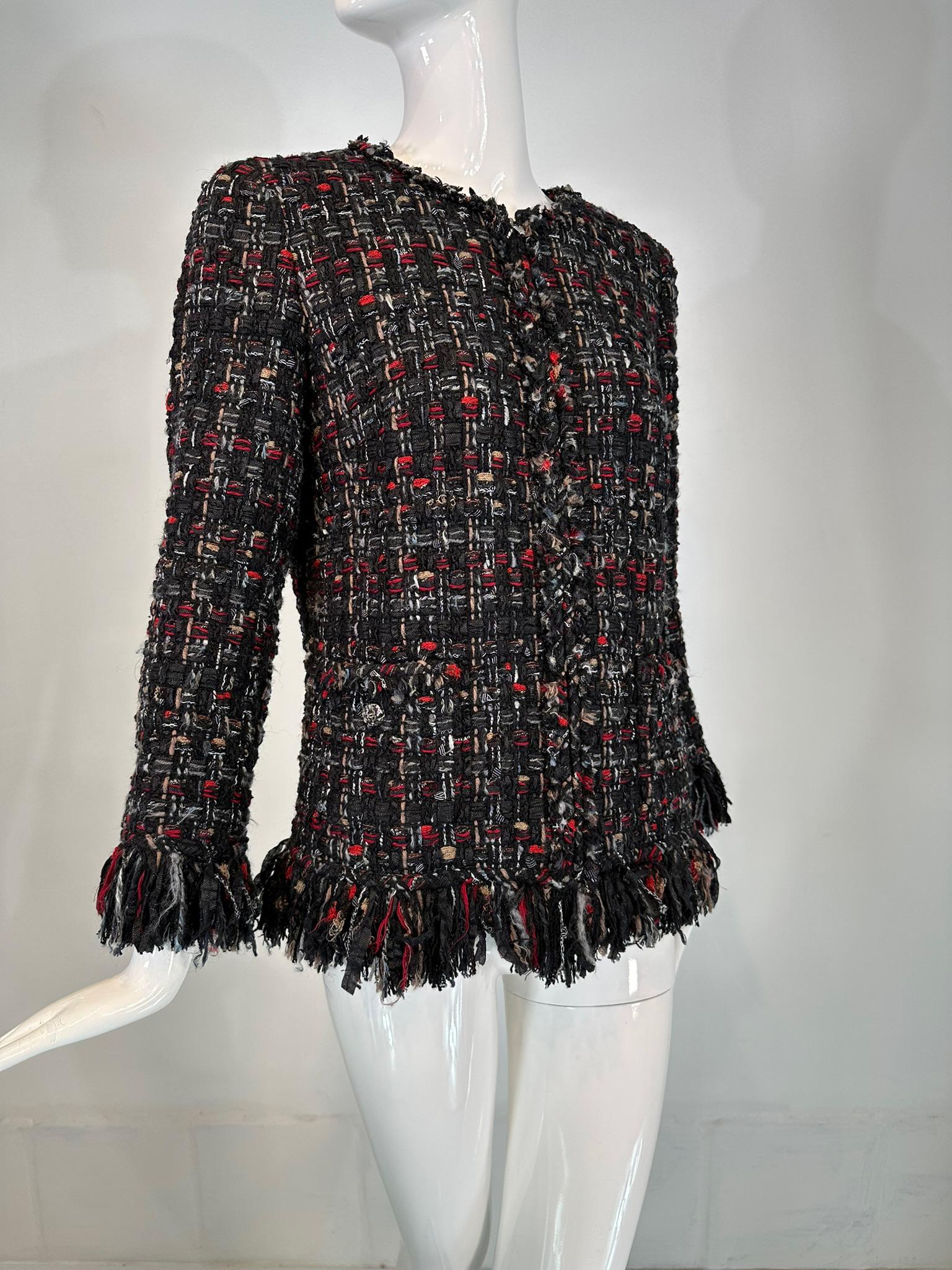 Chaqueta Chanel 2010 negra, roja, tostada y gris de tweed grueso con cremallera y ribete de flecos marcada en la talla 40.
Preciosa chaqueta en tonos negro, tostado, rojo y gris, confeccionada en un tejido de tweed grueso. Escote joya y frunces