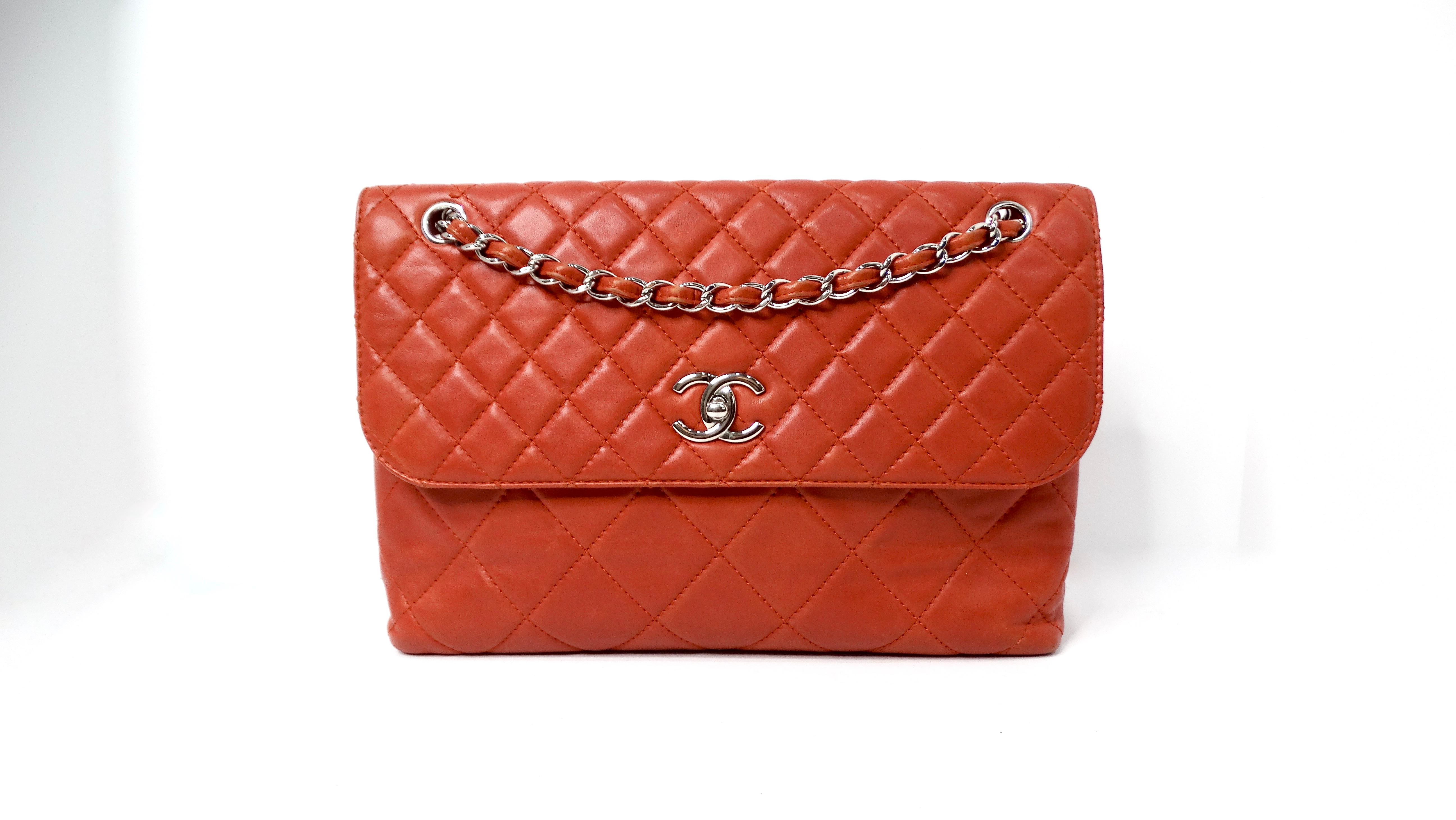 The Chanel 2010 Burnt Orange In-The-Business Quilted Lambskin Large Single Flap Bag is an exquisite piece that encapsulates the essence of modern sophistication. Crafted from sumptuous lambskin with a rich burnt orange hue, this bag adds a vibrant