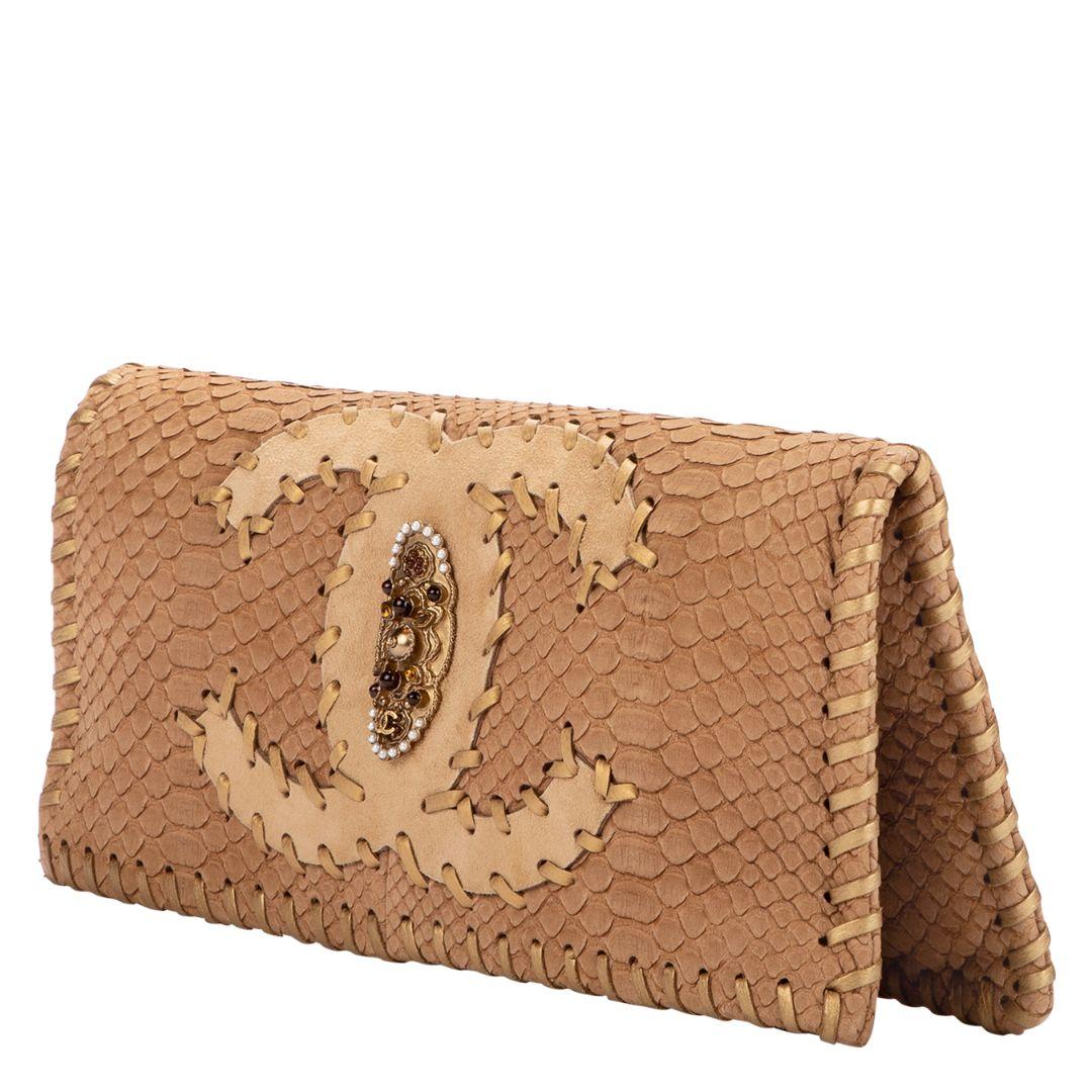 Looking for that perfect clutch for all your summer weddings? The incredible Chanel clutch is the ideal solution! Rendered in a brown python leather with golden brass hardware and crystal embellishments. The zipper closure opens to a very roomy