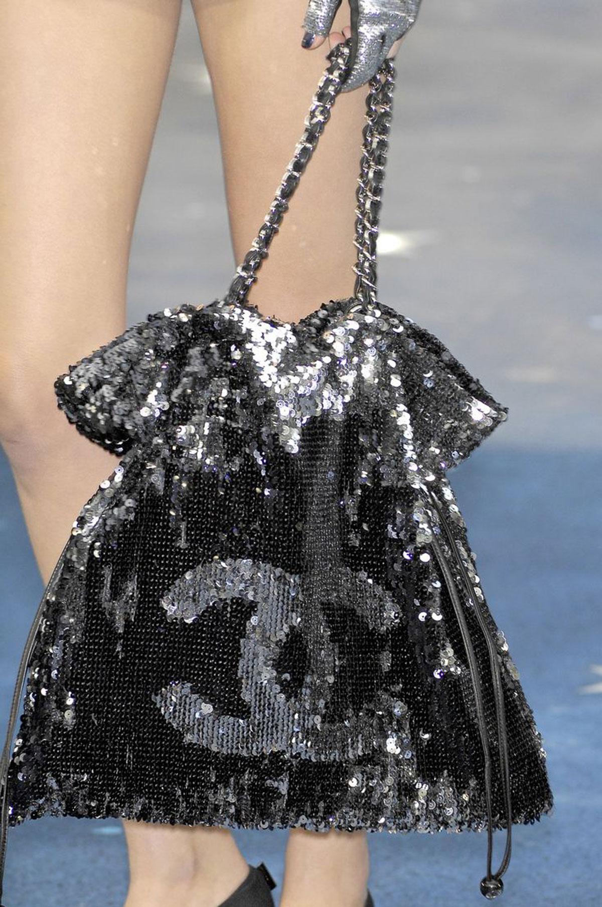 Chanel Timeless Metallic Sequin Drawstring CC Reversible Large Rare Silver Tote

Year: 2010 Runway {Vintage 14 Years}

Silver hardware
Leather drawstrings on side with CC mirrored logo tab
Interwoven chain and leather shoulder straps. 
Magnetic