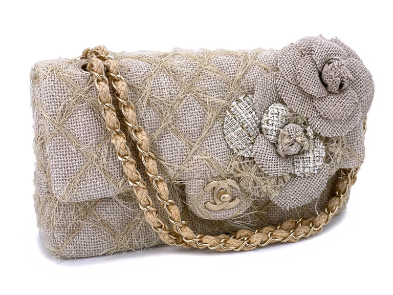 Store item: 66611
Exclusively from the 2010 runway is this very rare Chanel taupe beige raffia classic flap bag with camellia accents and brushed gold hardware. 

Exquisite attention has been made to the details - the quilts are made with