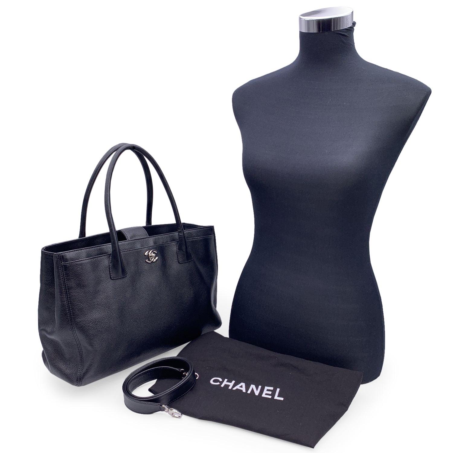 Stunning Chanel 'Executive' Tote Bag in black pebbled leather. Period/Era: 2010/2011. Silver metal CC - CHANEL logo on the front. Double top handles and removable shoulder strap. Double magnetic button closure on top. Front and rear pocket. Black
