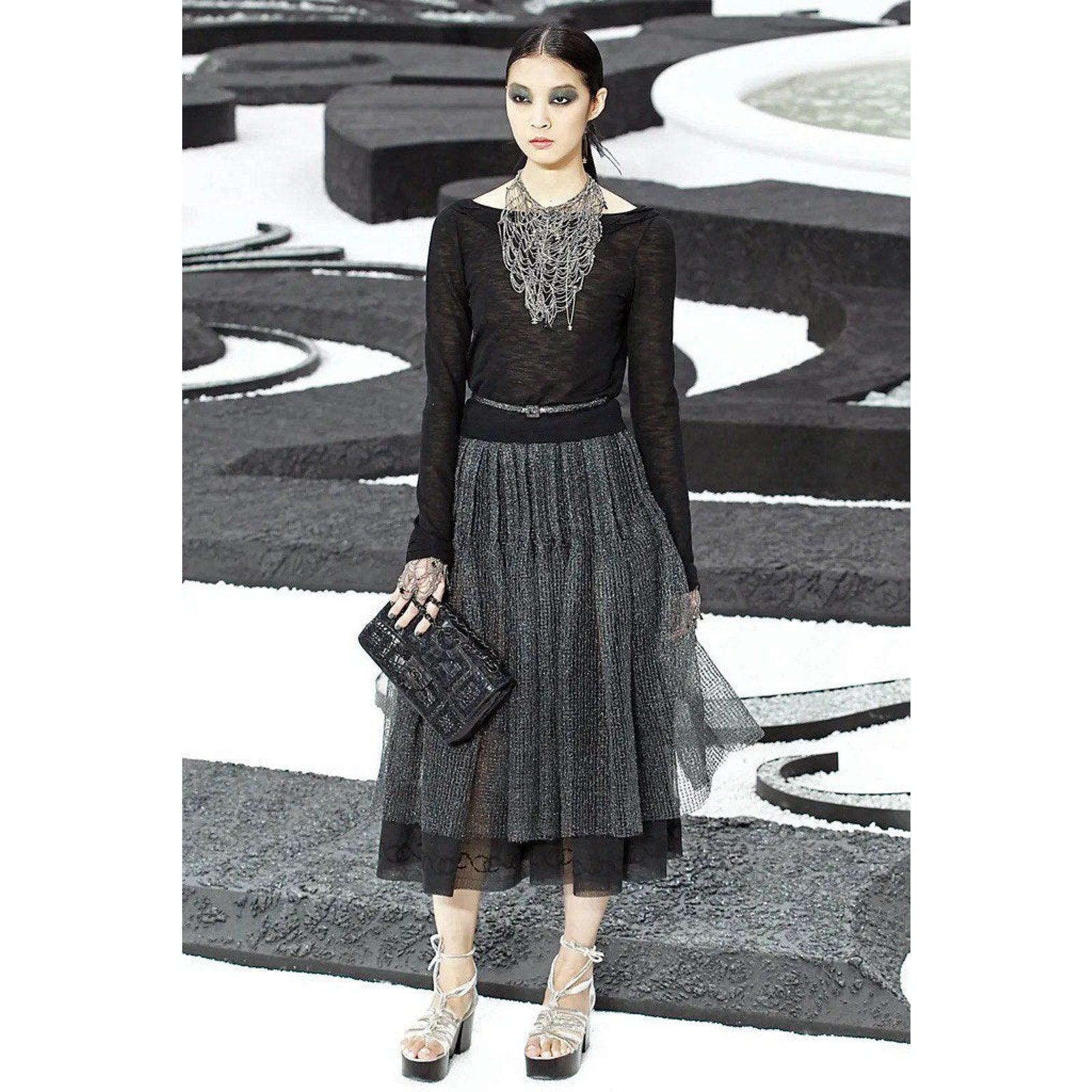 Eleva il tuo guardaroba con questo splendido top Chanel 2011 in viscosa nera taglia 36! Questo top minimalista è caratterizzato da bottoni decorativi sulla schiena e da una scollatura morbidamente drappeggiata, che aggiunge un tocco di raffinatezza