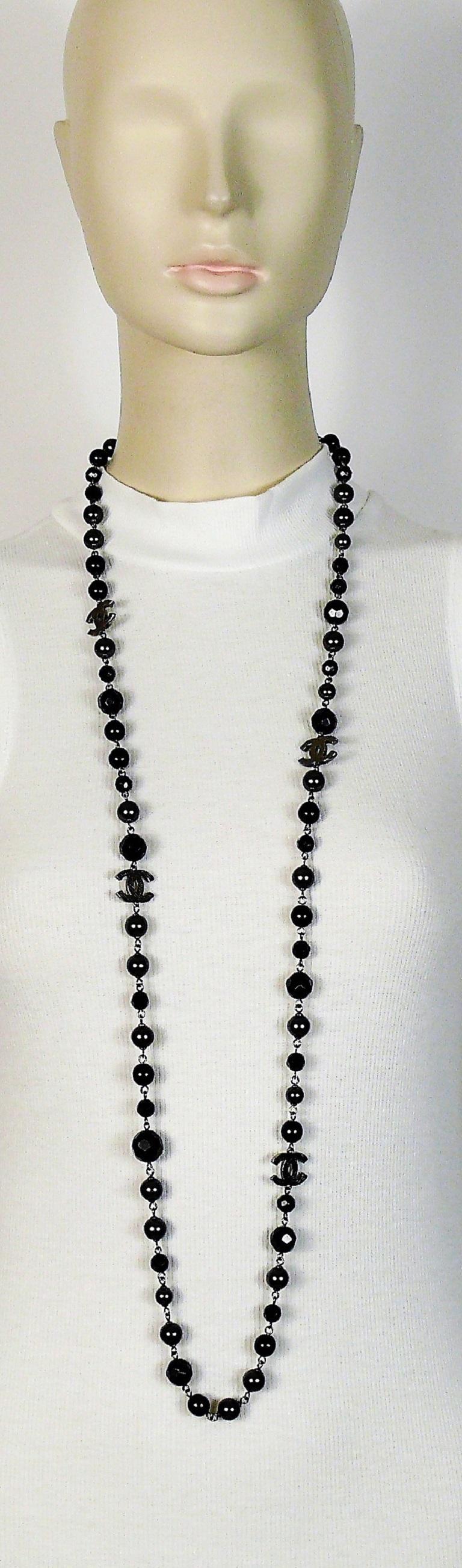 CHANEL necklace featuring a strand of black beads and grey faux pearls with four silver tone textured CHANEL logos.

This necklace can be wrapped two times around the neck.

Lobster clasp closure.

Embossed CHANEL A11 V  Made Made in