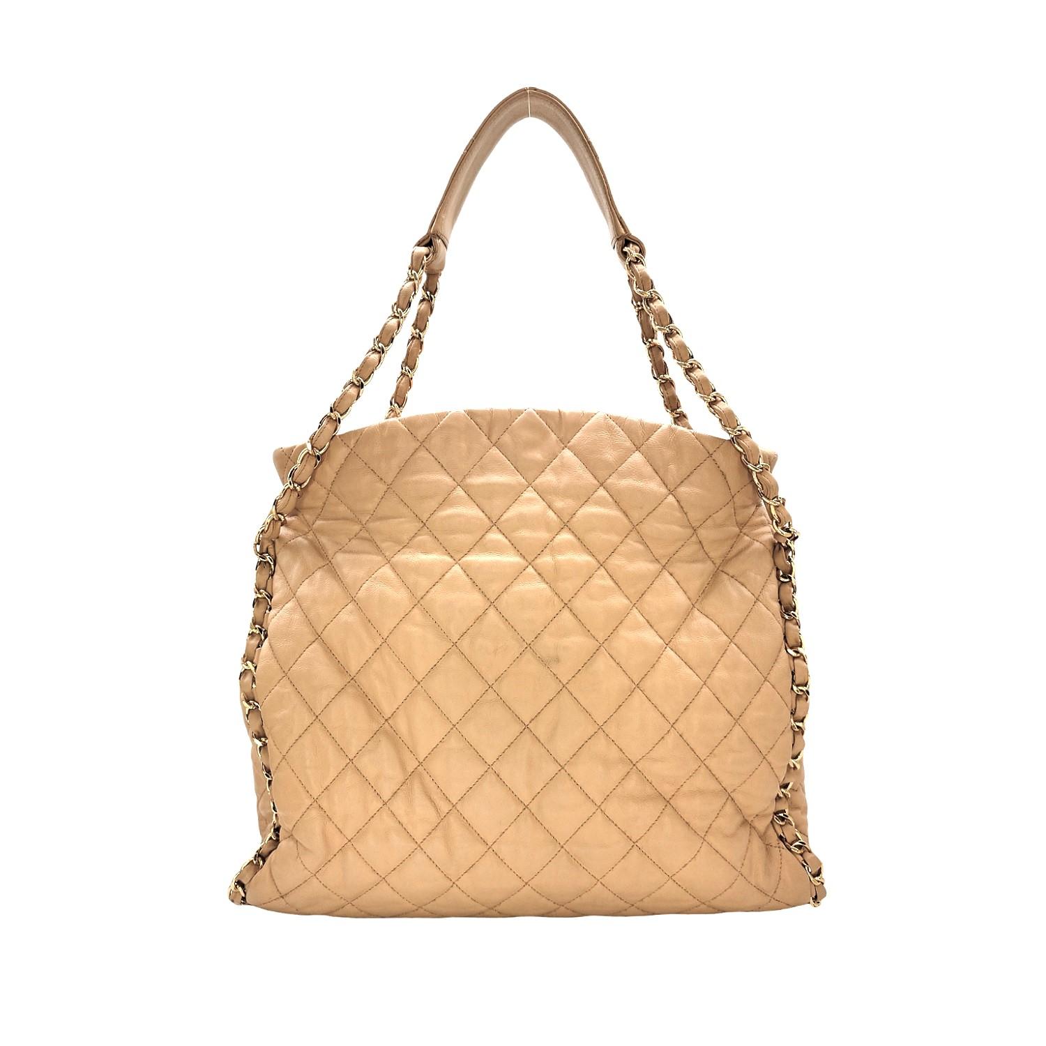 Elevate your style with the Chanel Chain Me Hobo Large. Made from luxurious calfskin in Italy, this designer piece features a magnetic snap closure and polished gold-tone hardware. Complete with zipper and patch pockets, it's perfect for organizing