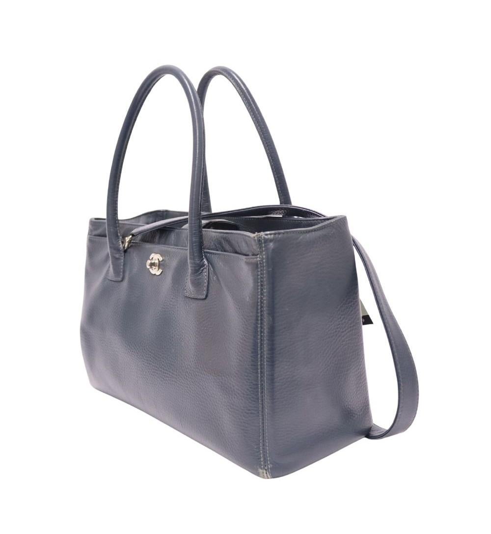 Chanel 2013/2014 Navy Leather Large Cerf Executive Tote, Features CC Logo, Removable Strap, Removable Pouch and Two Interior Pocket.

Material: Leather
Hardware: Silver
Height: 24cm
Width: 36cm
Depth: 12cm
Handle Drop: 16cm
Strap Length: