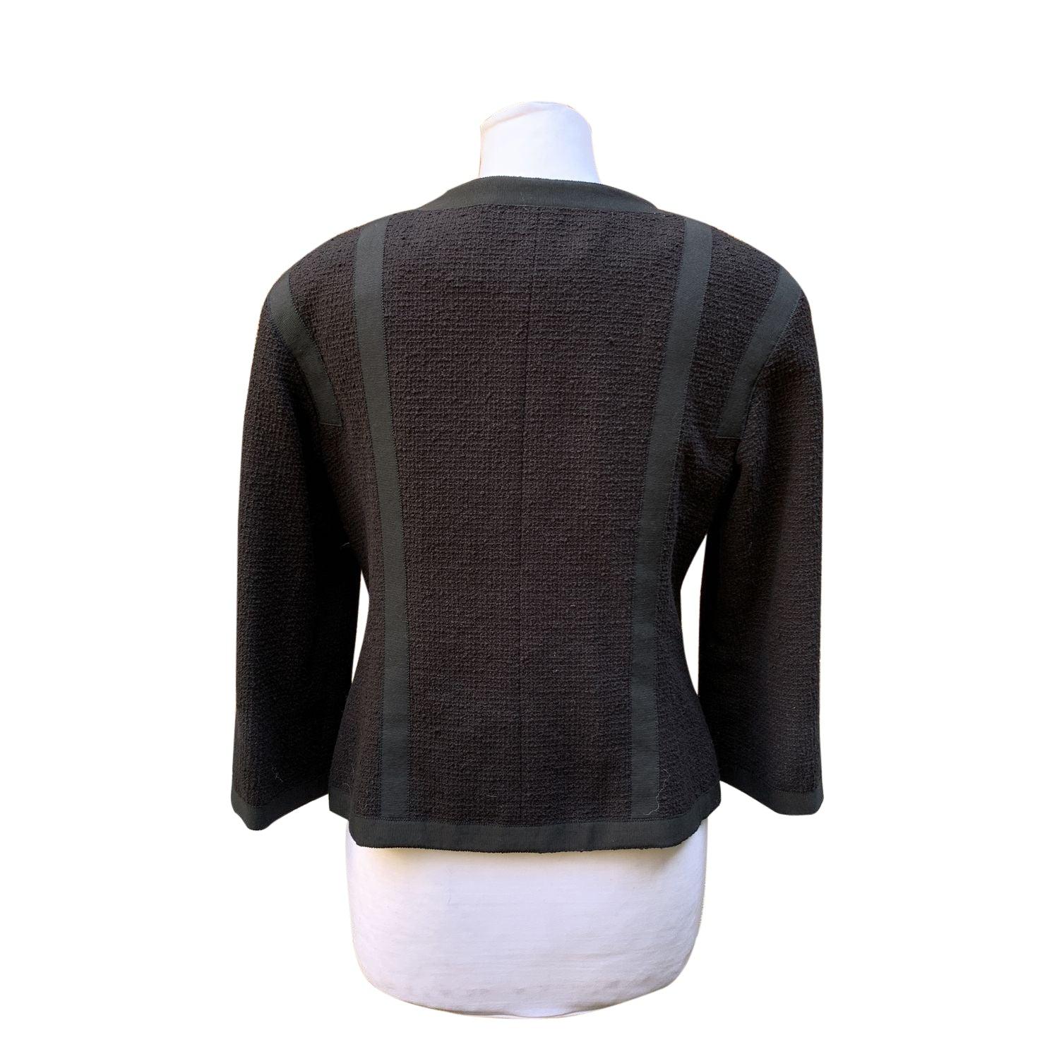 Un pezzo straordinario della Collection'S 2013 di Chanel, questa giacca nera con maniche a 3/4 cattura il perfetto equilibrio tra eleganza senza tempo e raffinatezza moderna. Con un classico scollo rotondo e un delicato bordo in gros-grain, offre