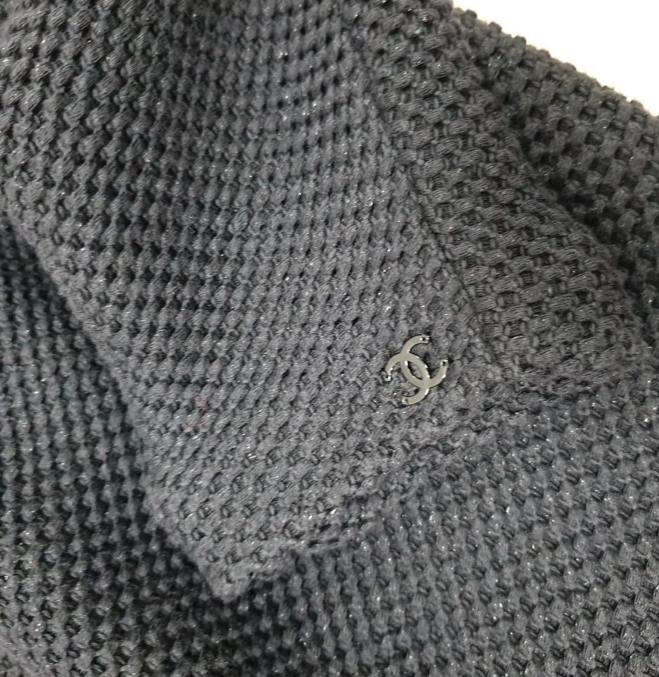 Faites sensation à chaque fois que vous sortez dans cette magnifique robe Chanel.

V.I.I. et dos,  Détails du nœud, fermeture éclair cachée au dos avec le logo CC, Tissu en maille de coton avec des paillettes subtiles rendant cette robe très