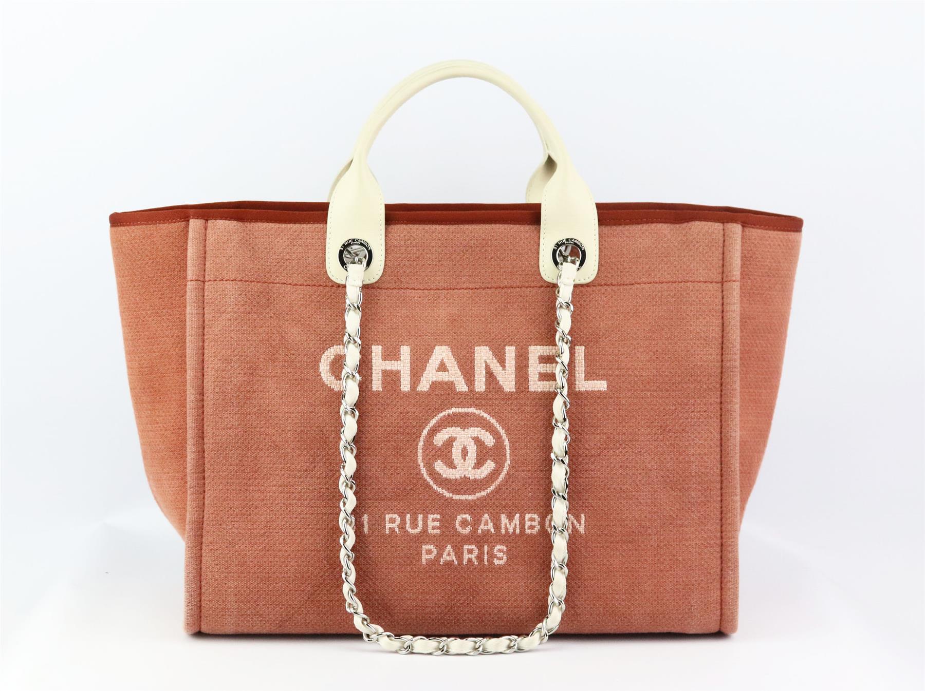 Realizzata in Italia, questa bellissima tote bag Chanel Medium 'Deauville' del 2013 è stata realizzata in tela rosa all'esterno e in tela abbinata all'interno. Il pezzo è decorato con una scritta 'CHANEL' e un dettaglio CC sulla parte anteriore, ed
