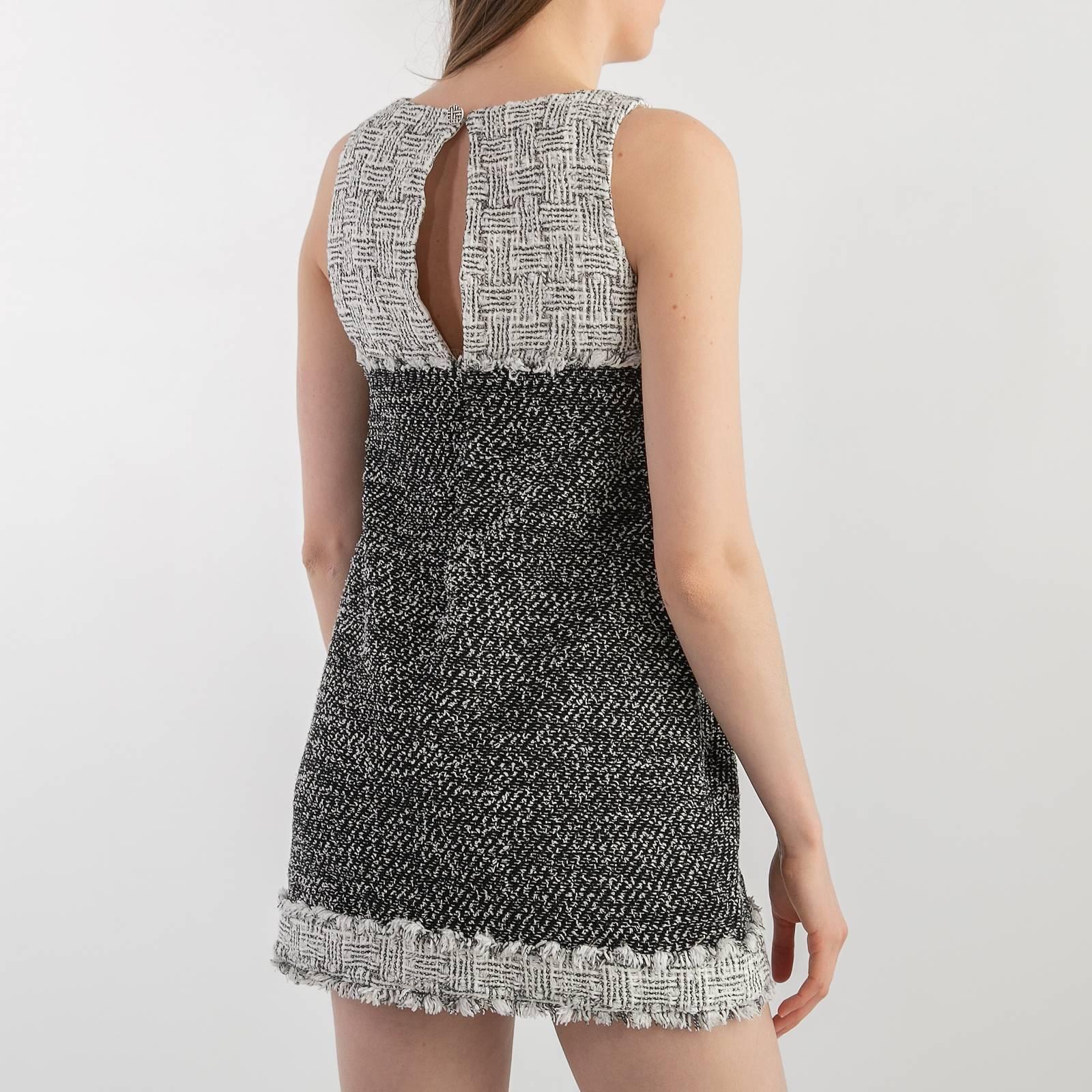 
Chanel 2014 Schwarz Elfenbein Tweed Combo Ärmelloses Etuikleid. Aus der Kollektion Frühjahr/Sommer 2014. 
Mini-Kleid in A-Linie. Rundhalsausschnitt. Druckknopfverschluss auf der Rückseite. Fransenakzente an Saum und Brust. Vollständig mit