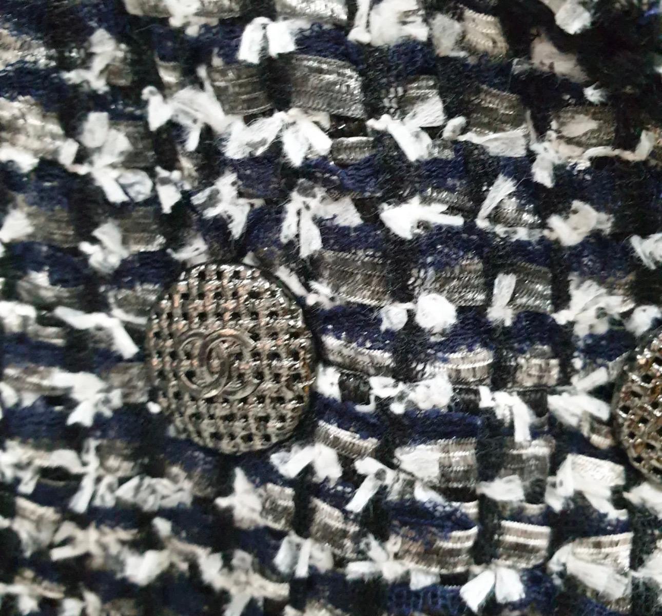 From Pre-Spring/summer 2014
100% authentic Chanel double-breasted Bouclé tweed jacket in black, navy and white polyamide (77%), viscose (21%) and polyester (2%). Double lined in grey logo printed silk (100%). 
Two buttoned patch pockets in the front