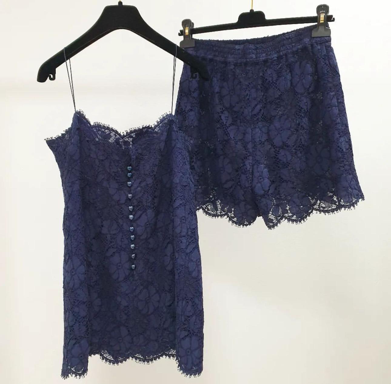 2 pieces set

Chanel 2014 lace camisole and shorts in navy blue cotton (75%), viscose (15%) and nylon (10%). 

Opens with eleven buttons and a hook on the back. 

Lined in silk (100%)
Measurements

Sz.36
Excellent condition.