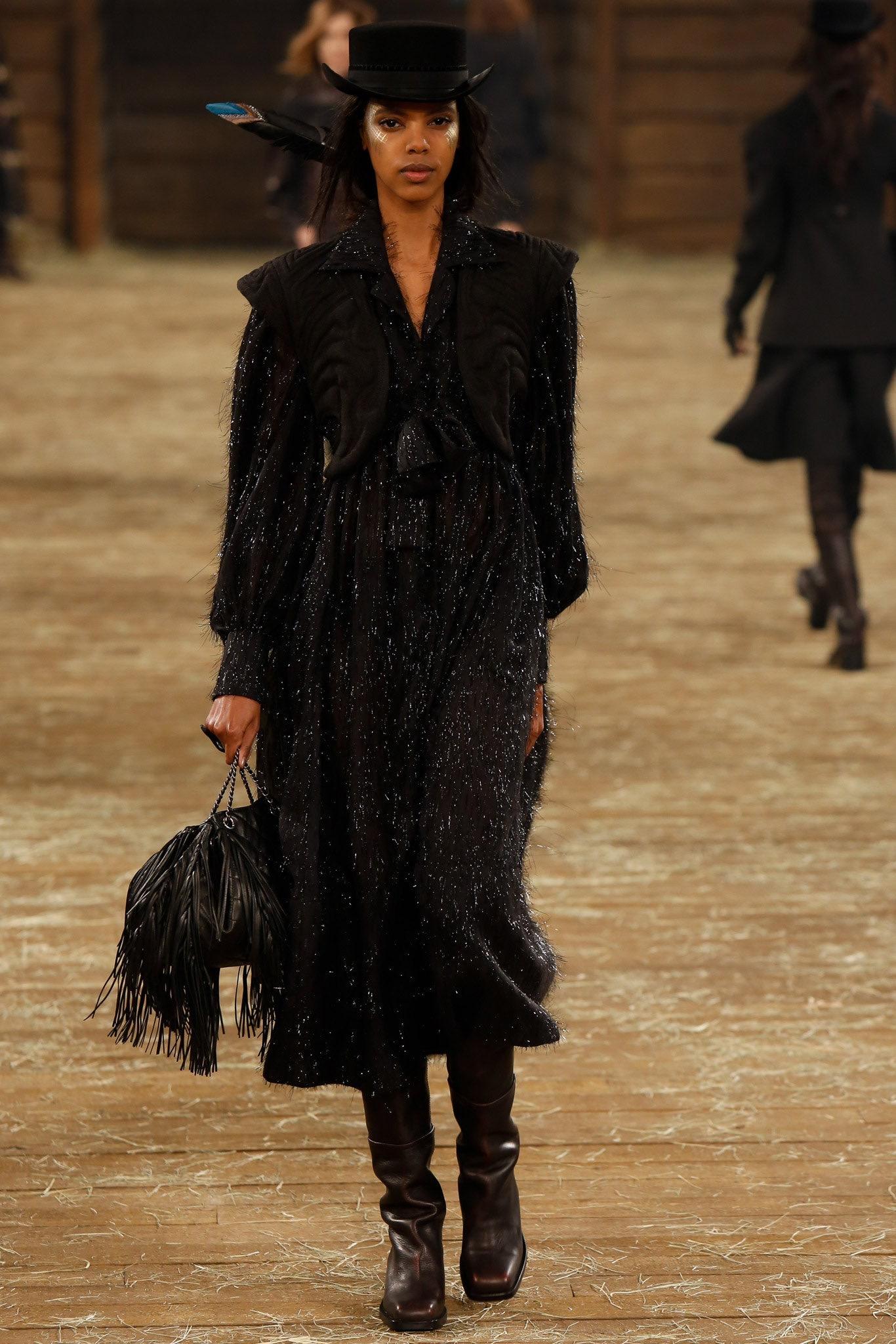 Introducing the Chanel 2014 Paris-Dallas Black Quilted Lambskin Drawstring Fringe Bucket Bag, a true statement piece from Karl Lagerfeld’s iconic collection. This exquisite bag is crafted from luxurious black lambskin leather, featuring impeccable