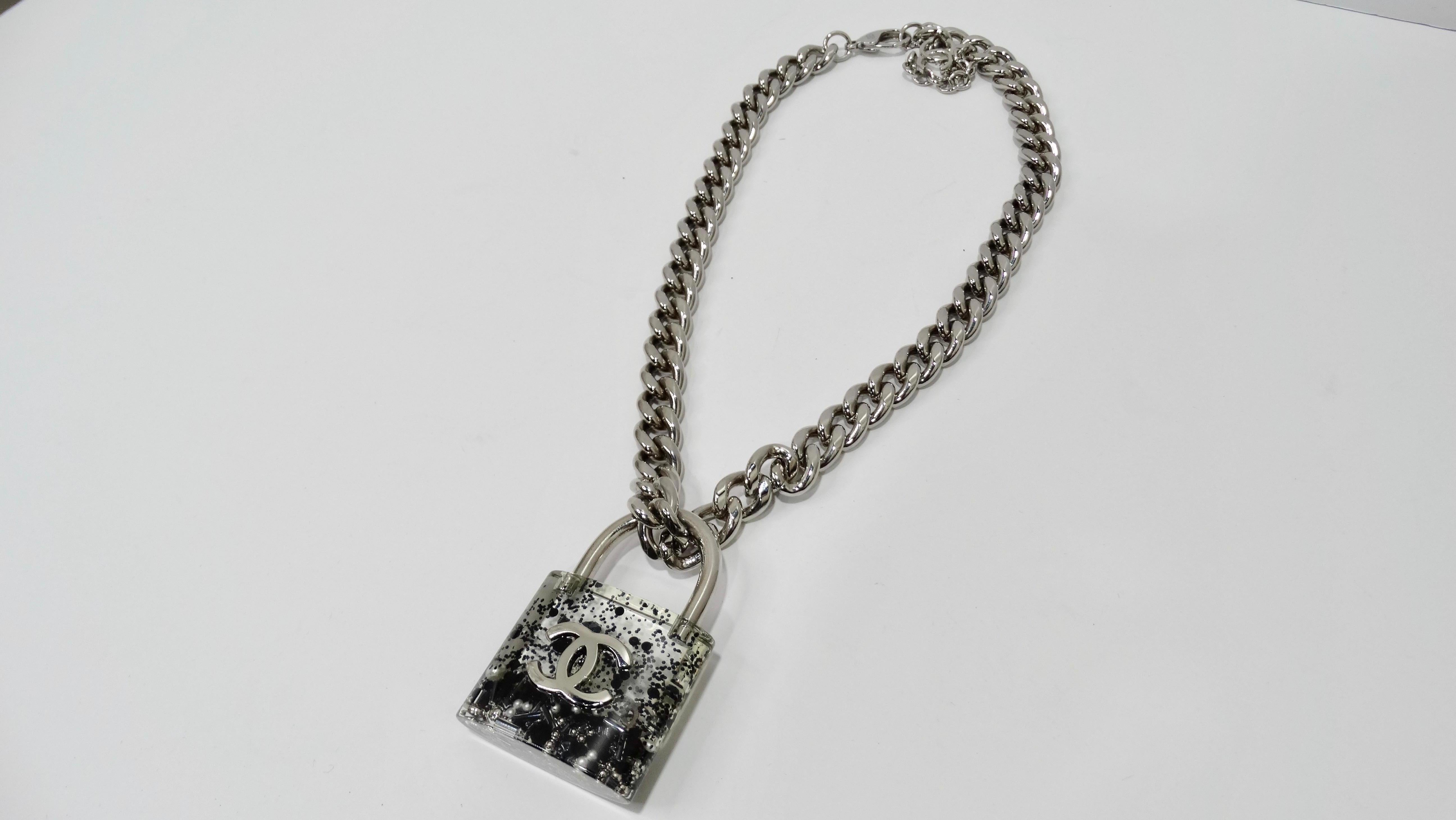 Lock this necklace down before it's too late! Circa fall of 2014 from Chanel's iconic grocery store collection, this large chain link necklace features a CC logo resin padlock filled with beads, glitter, mini CC's and pearls. Adjustable high