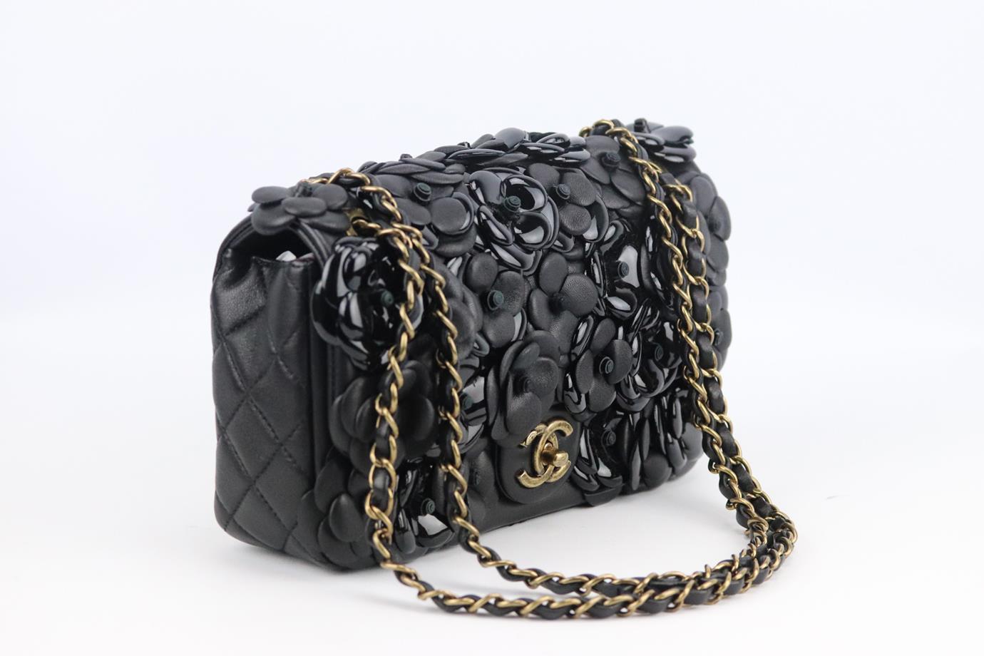 Chanel 2015 Classic small camellia leather single flap bag. Made from black leather with CC gold-tone hardware on the front and layered Camelia design, it has a large internal compartment with two slit pockets. Black. Twist lock at front. Comes with