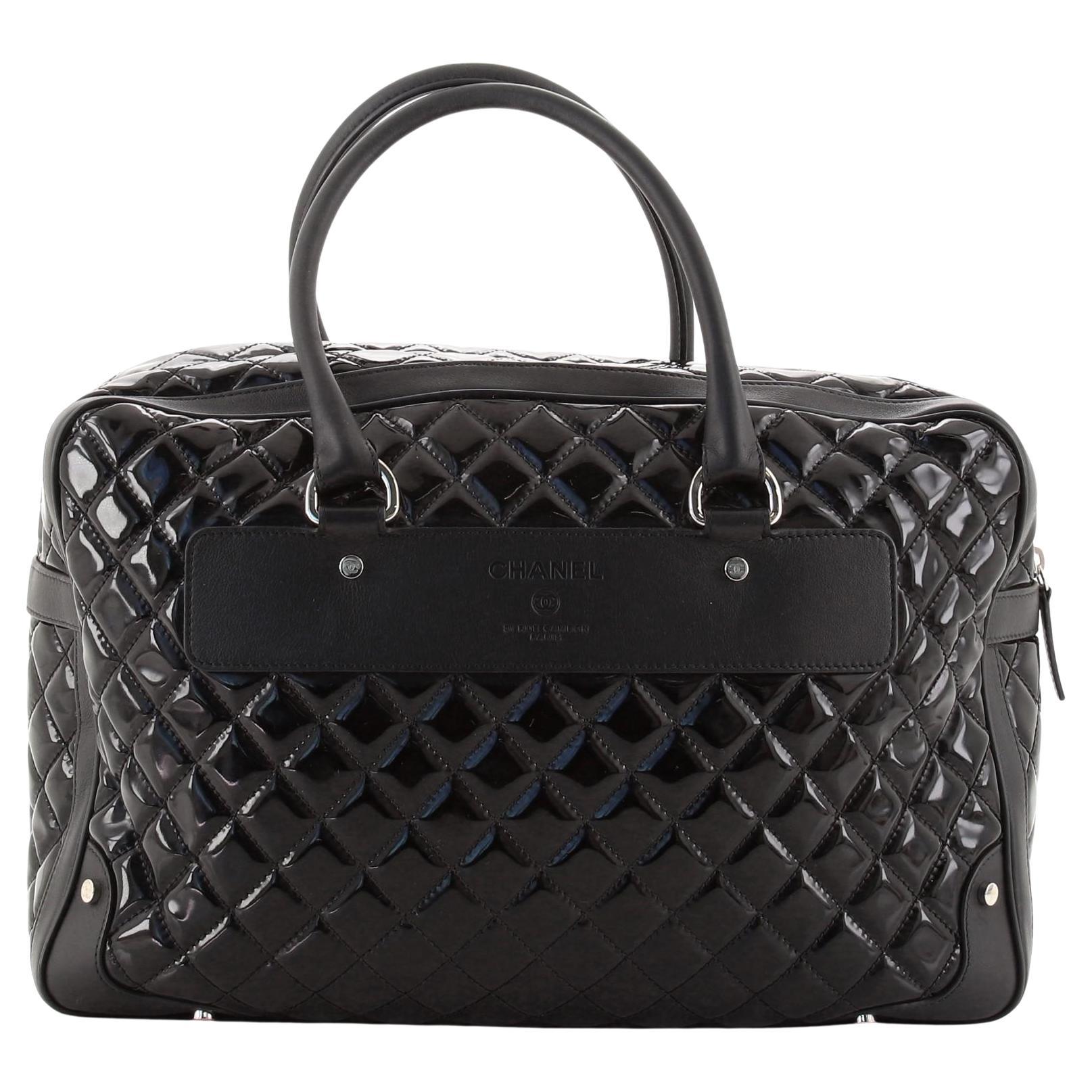 Chanel 2015 Timeless Quilted Carry-on Travel Tote Royal Black Patent Leather Bag

Spring Summer 2015 
Silver hardware
Black patent leather
Black calfskin leather trims
Dual-rolled leather handles
Exterior zip pocket with a padlock and a hanging