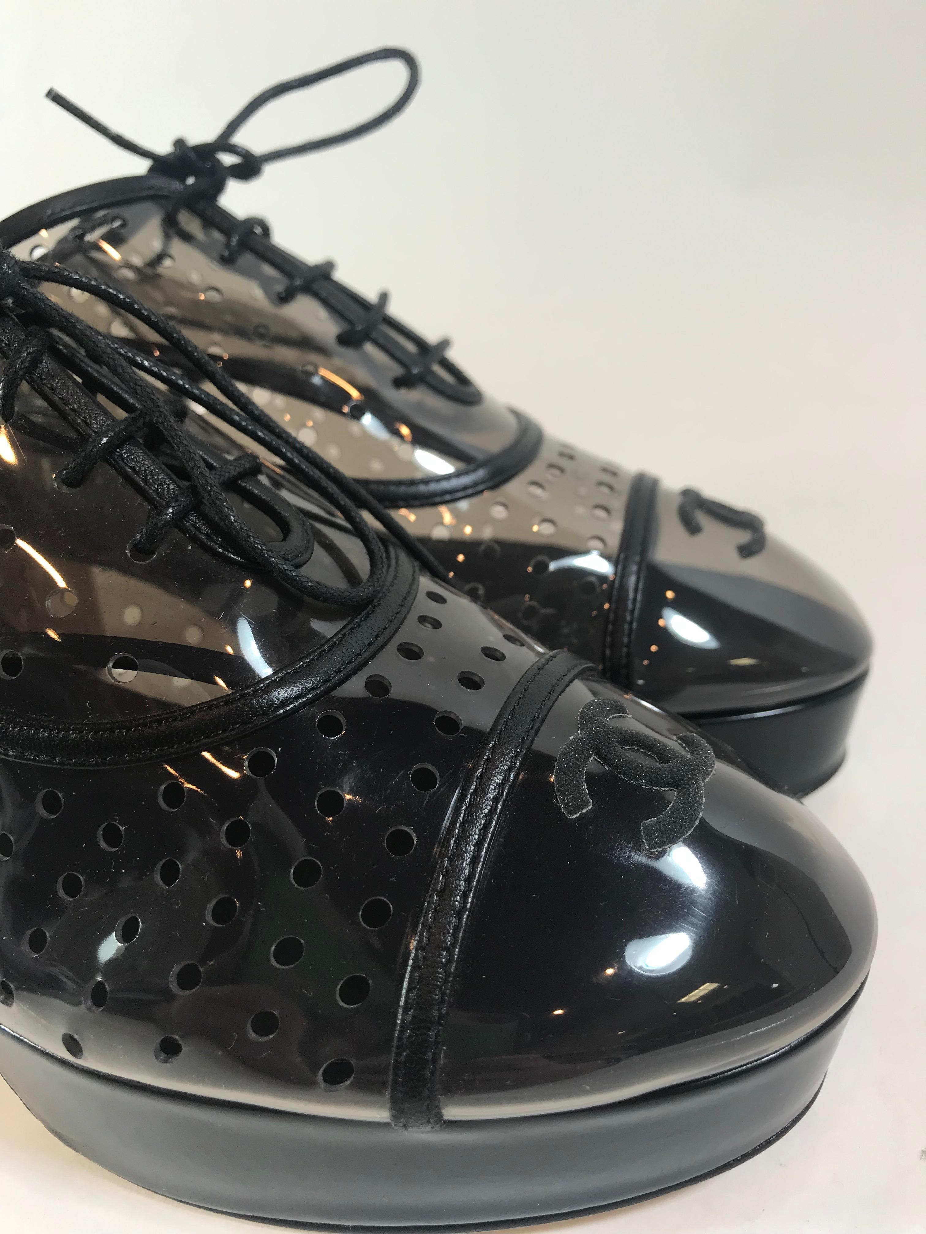 From the 2016 collection. Clear PVC and black patent leather. Round-toe. Cap toe. Lace-up tie closures at uppers. Interlocking 