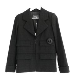 Giacca Chanel 2017 17C in tweed nero con spilla a forma di camelia