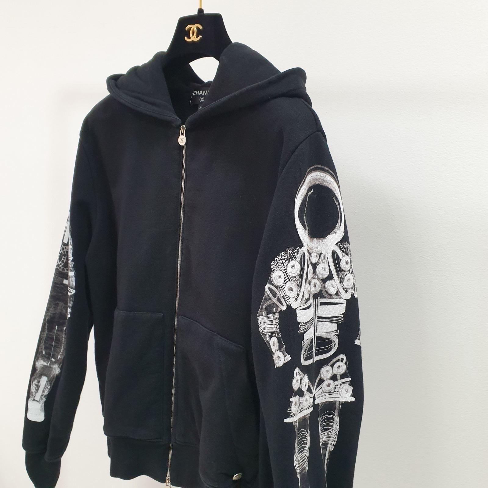 A stylish chanel hoodie to keep you warm when you are out and about. Featuring a zipper front and an astronaut print on sleeves, this hoodie is great for layering up with your favorite sneakers.

Chanel 2017 Astronaut Zip-Up Hoodie Jacket in Black