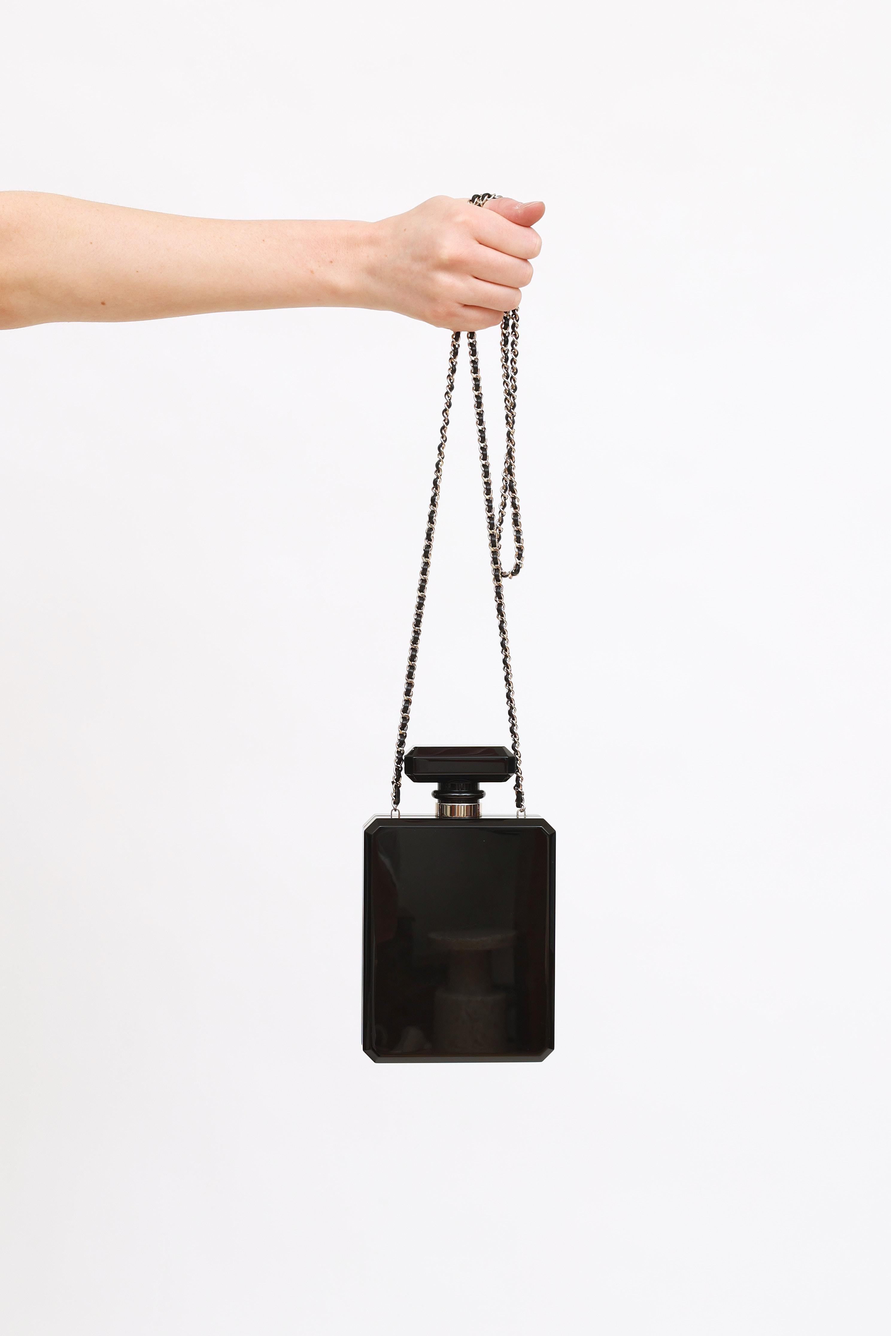 Gebrauchte Chanel Parfümflasche Minaudiere mit Perlenverzierung Clutch-Tasche mit schwarzem Plexiglas Parfüm Form Basis, fünf funkelnden Goldstreifen, Gold-Ton-Hardware und Logo-Plakette mit faux Perlen umrandet. Die Push-Down-Verschlussöffnung