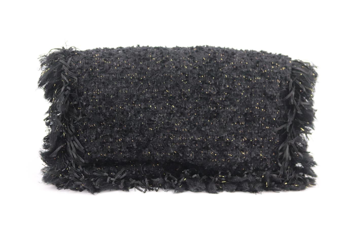 Chanel 2017 cc detailed fringed tweed clutch. Made from black tweed with CC gold-tone hardware on the front with fringed edge, it has a large internal compartment with zipped pocket. Black. Magnetic fastening at front. Comes with authenticity card.
