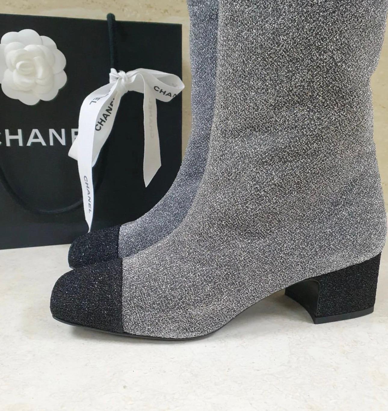 Chanel boots in silver glitter featuring a black patent leather block heel and square cap toes. They have been adorned with the iconic CC logo at the top and come equipped with comfortable leather-lined insoles. 
Sz.39
Never warn. Just tried