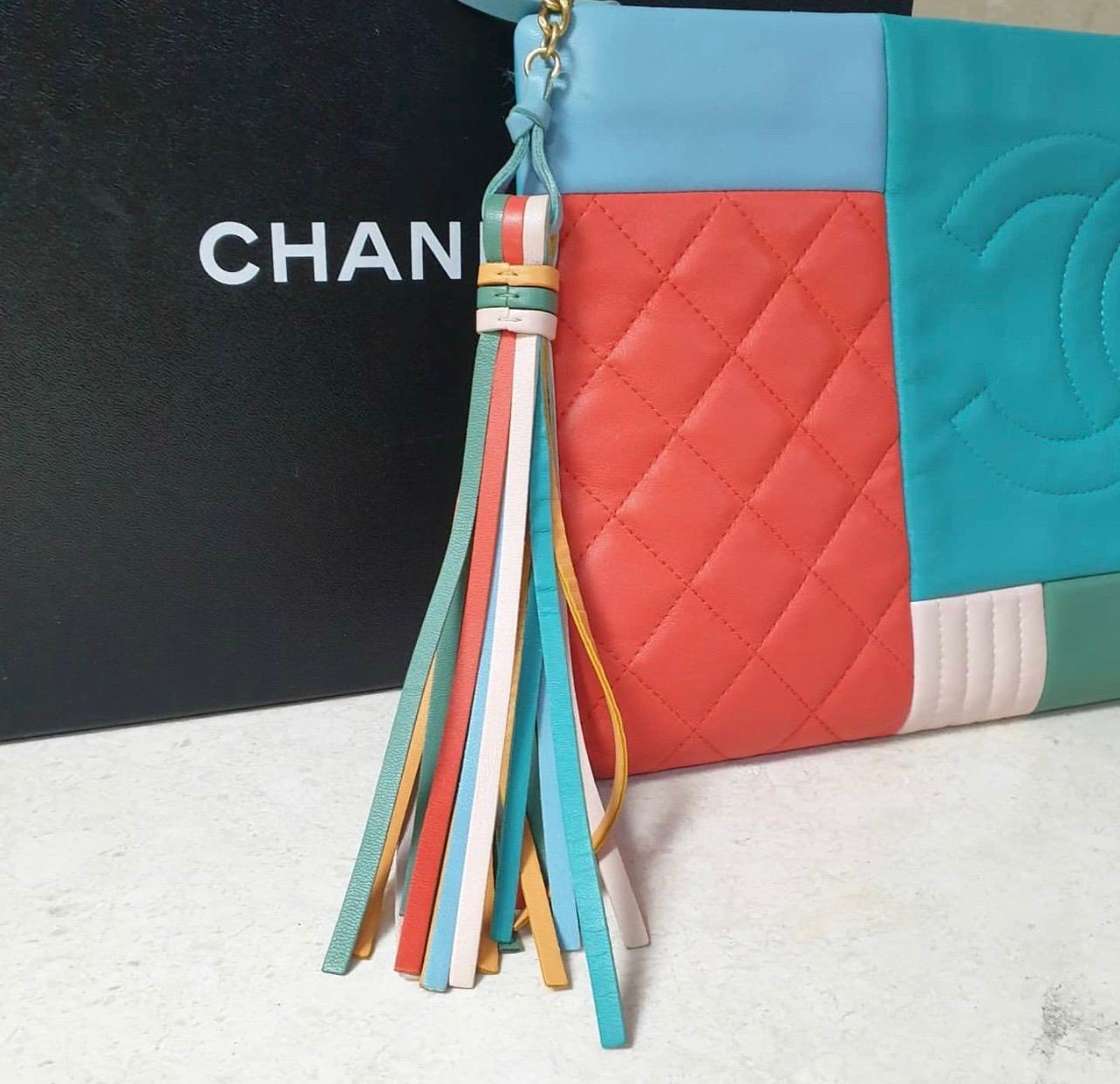 Dalla collezione Cruise 2017. Astuccio Chanel Large in pelle d'agnello trapuntata colorblock arancione, blu e multicolore con finiture dorate, fodera in nylon trapuntato blu e chiusura a zip sulla parte superiore con dettaglio di nappe.

Senza