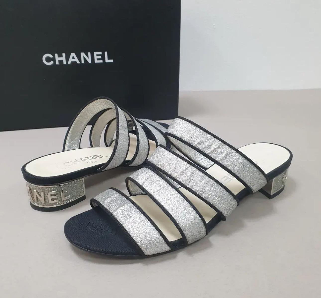     Chanel Sandals
    From the 2018 Collection by Karl Lagerfeld
    Silver
    Interlocking CC Logo
    Grosgrain & Glitter Accents
    Multistrap


Very good condition.
Signs of wear seen on pics.
Sz. 37
No box. No dust bag