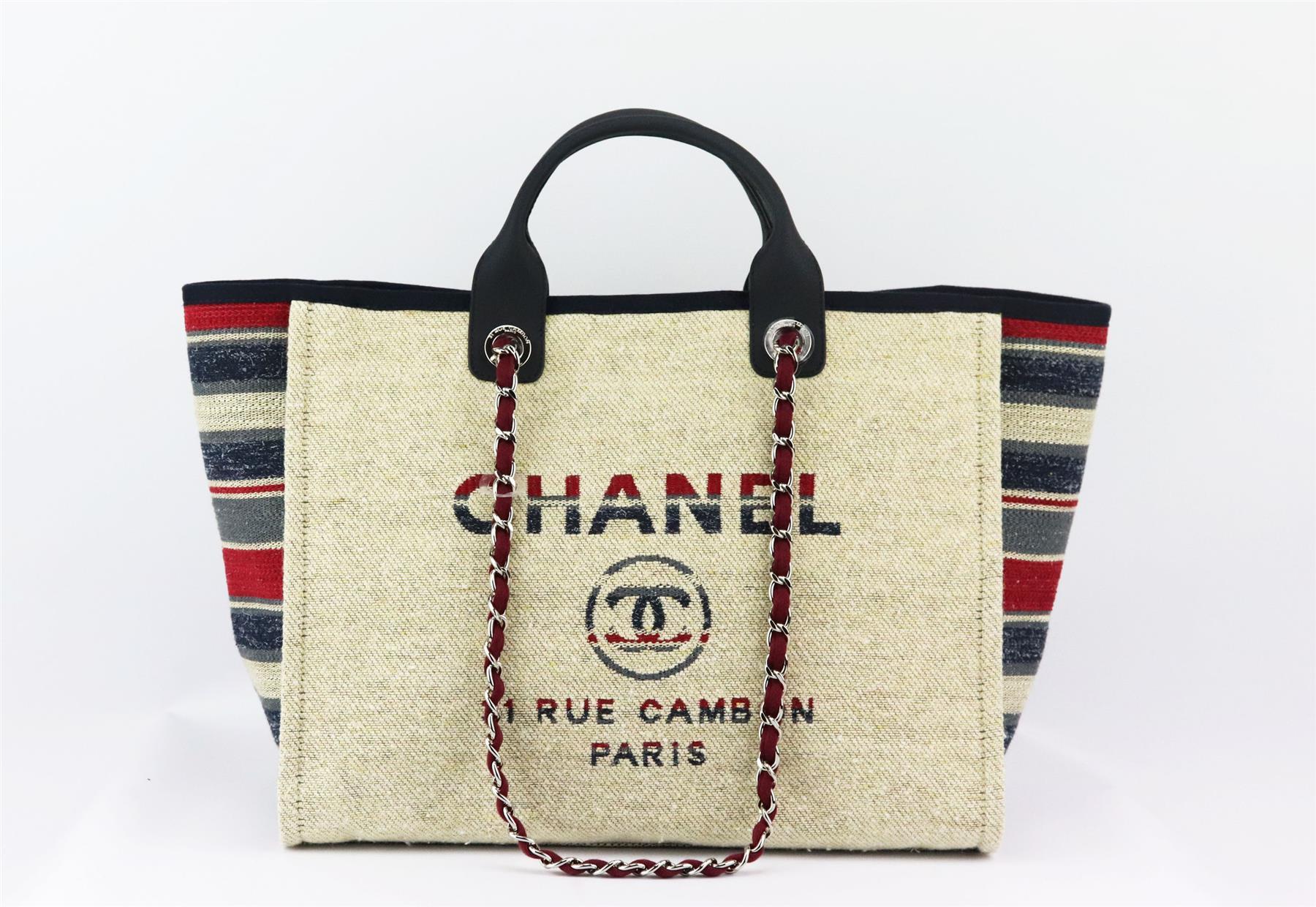 Made in Italy, this beautiful 2018 Chanel Paris-Hamburg Small ‘Deauville’ tote bag has been made from striped canvas and soft navy calfskin leather exterior and red canvas interior, this piece is decorated with a logo CC detail on the front and