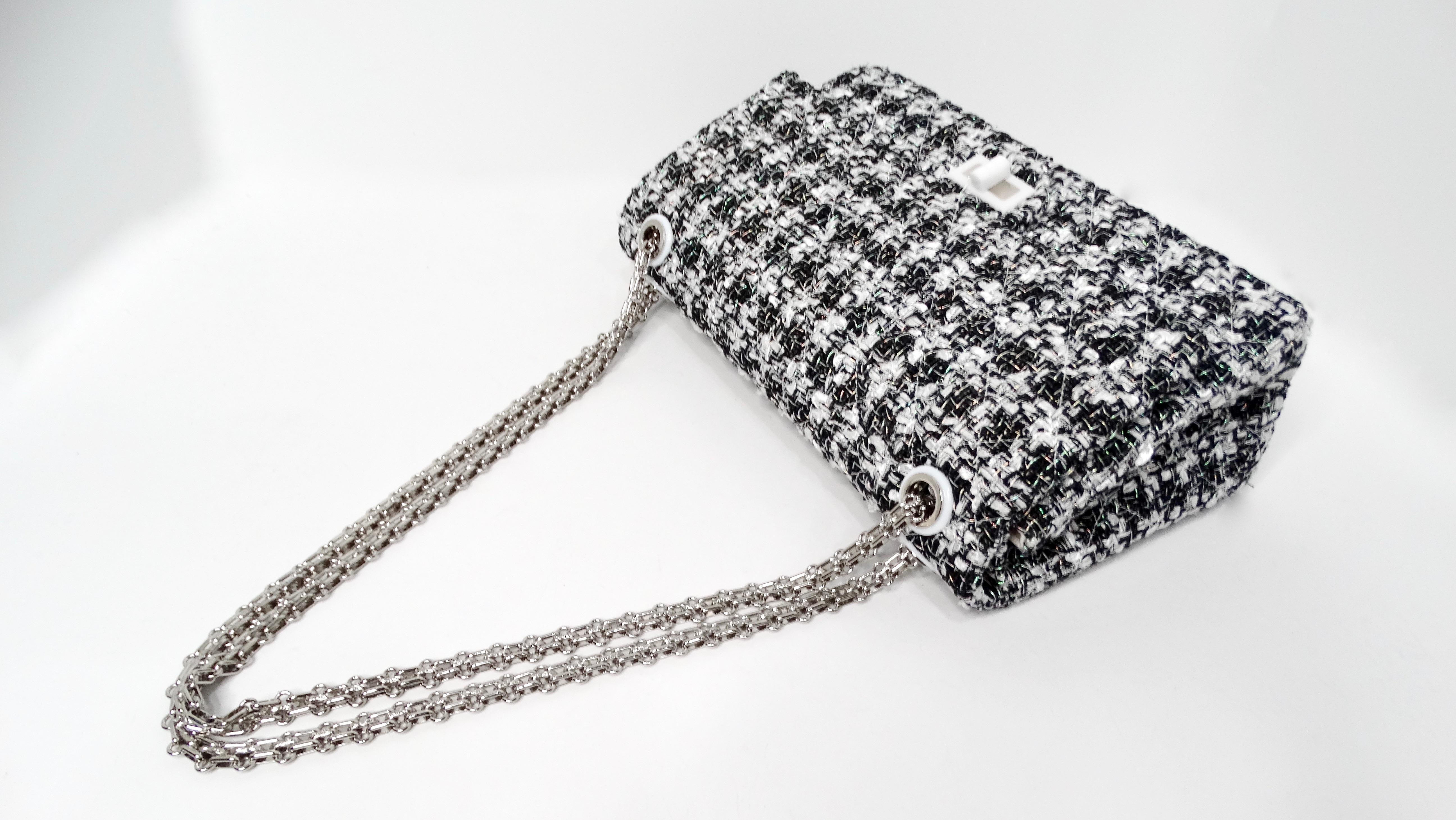 The Chanel 2019 2.55 Black & White Tweed Iridescent 226 Reissue Double-Flap Bag is a stunning modern classic that perfectly embodies the luxurious elegance synonymous with the House of Chanel. Crafted from exquisite black and white tweed, the bag is