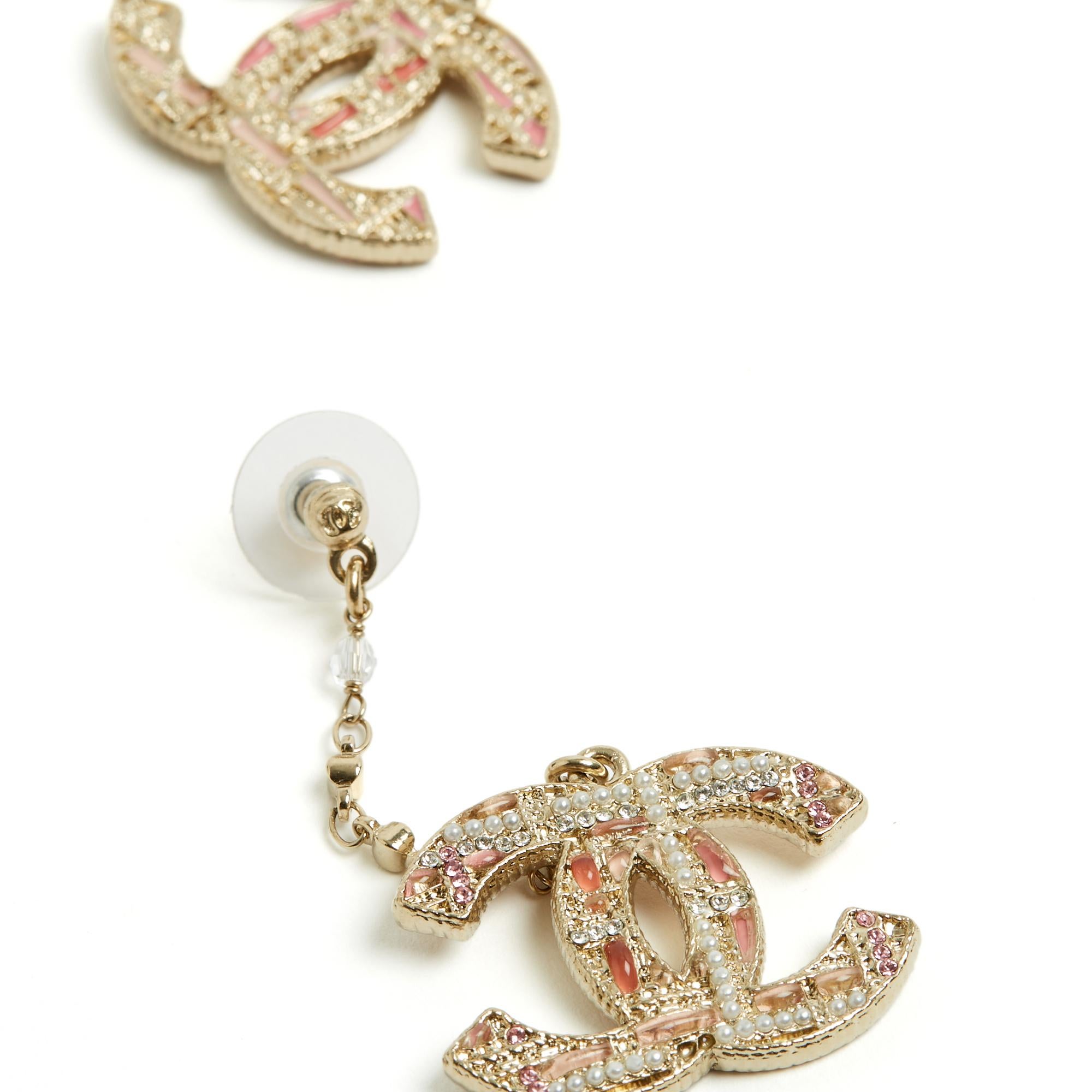 Chanel stud earrings from the AH2019 collection in gold-plated metal, composed of a CC-signed ear stud extended by a gold-plated metal chain and a large CC logo inlaid with fancy micro pearls, white and pink micro rhinestones and resin cabochons in