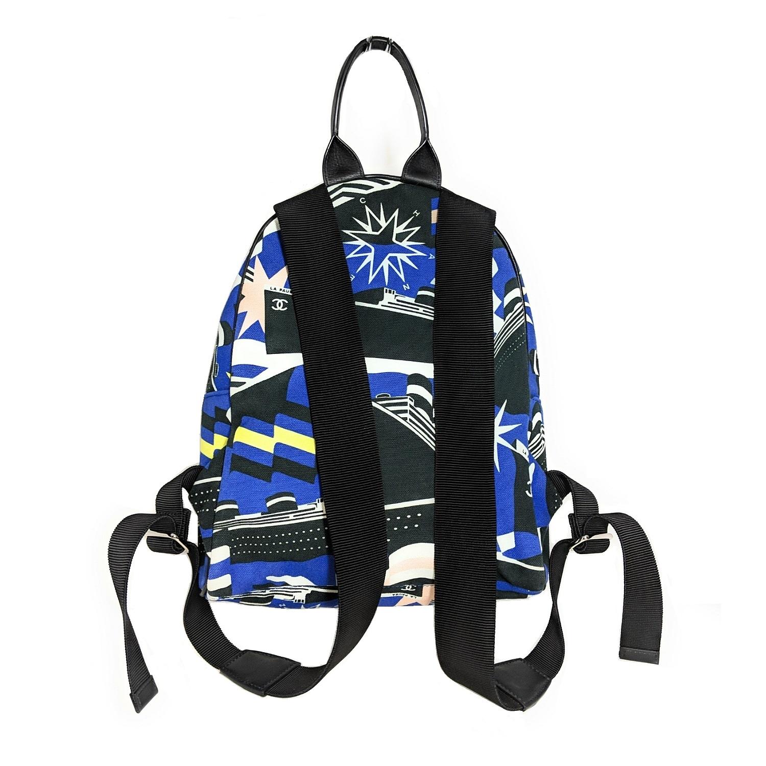 De la Colección Crucero 2019. Mochila Chanel La Pausa Bay de lona cobalto y negra con herrajes plateados, dos asas planas para el hombro, un asa superior plana de piel, un bolsillo con cremallera en el exterior, forro tejido tonal, un bolsillo con