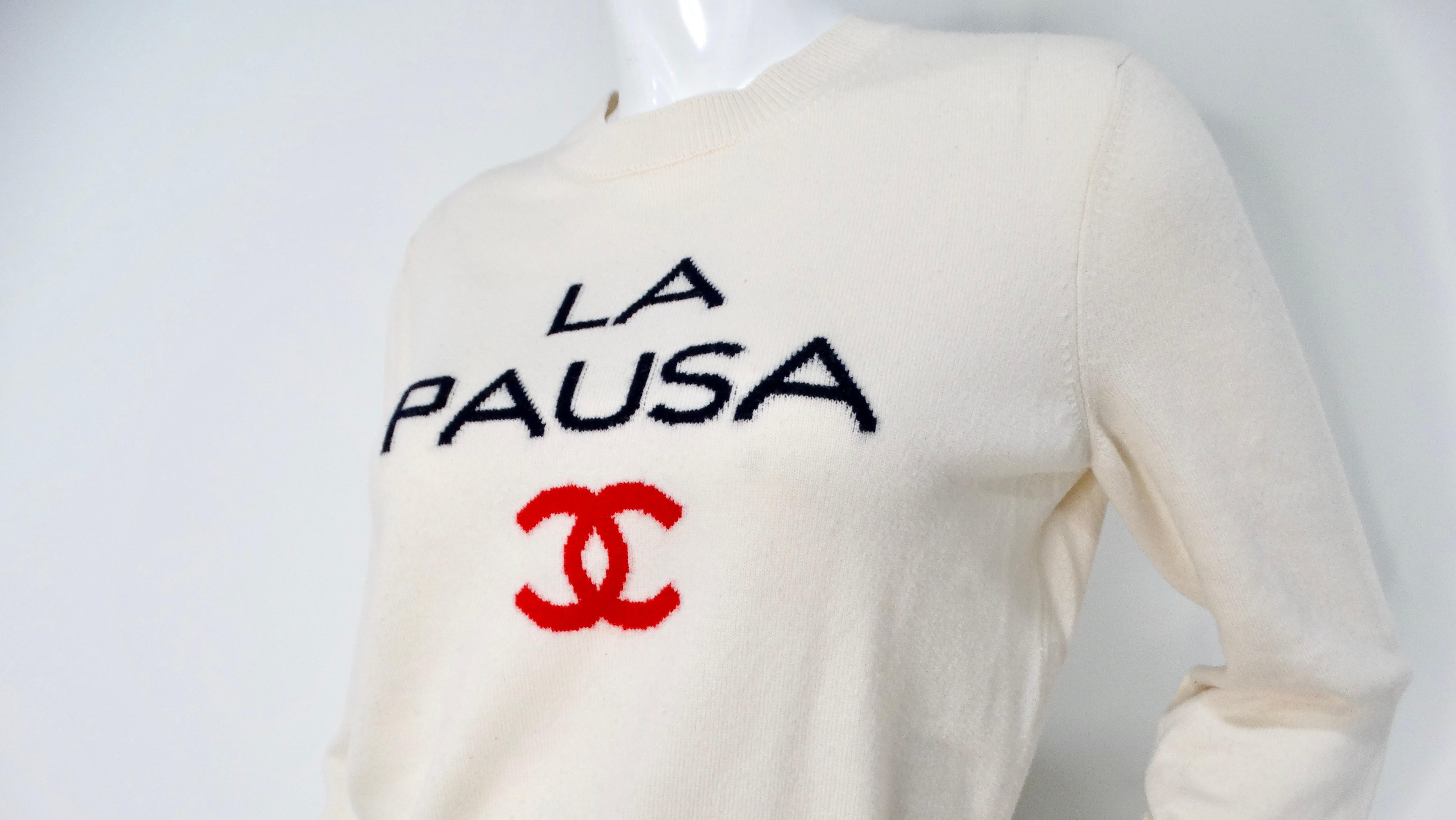 The Chanel 2019 La Pausa Cream Cashmere Sweater embodies elegance and comfort, making it a luxurious staple in any wardrobe. Crafted from soft cashmere, this sweater features the whimsical phrase 