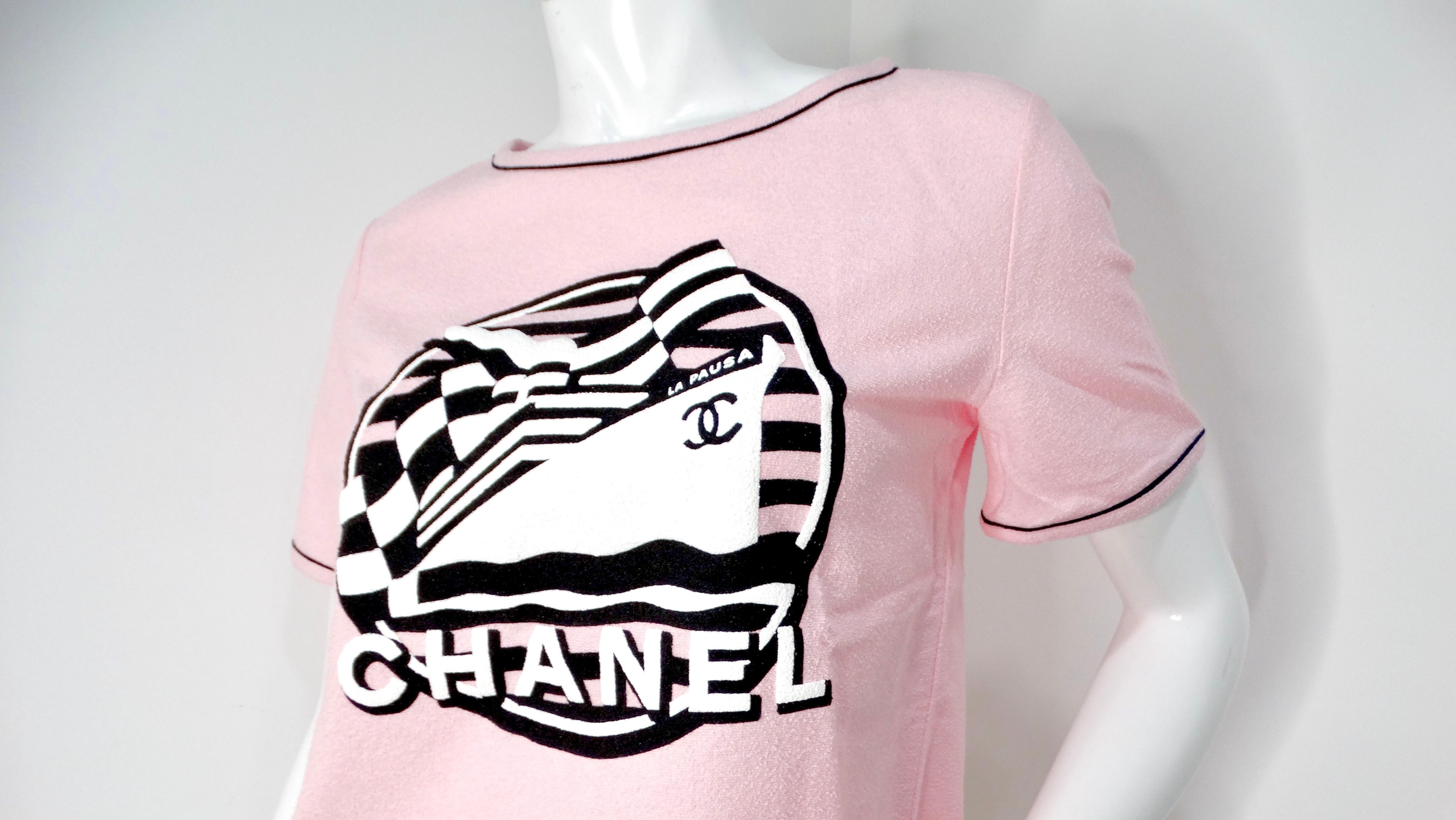 The Chanel 2019 La Pausa Cruise Print Pink Terrycloth T-Shirt is a charming piece that captures the essence of effortless chic. Crafted from terrycloth, the lovely light pink fabric exudes both comfort and elegance. Featuring a striking black and