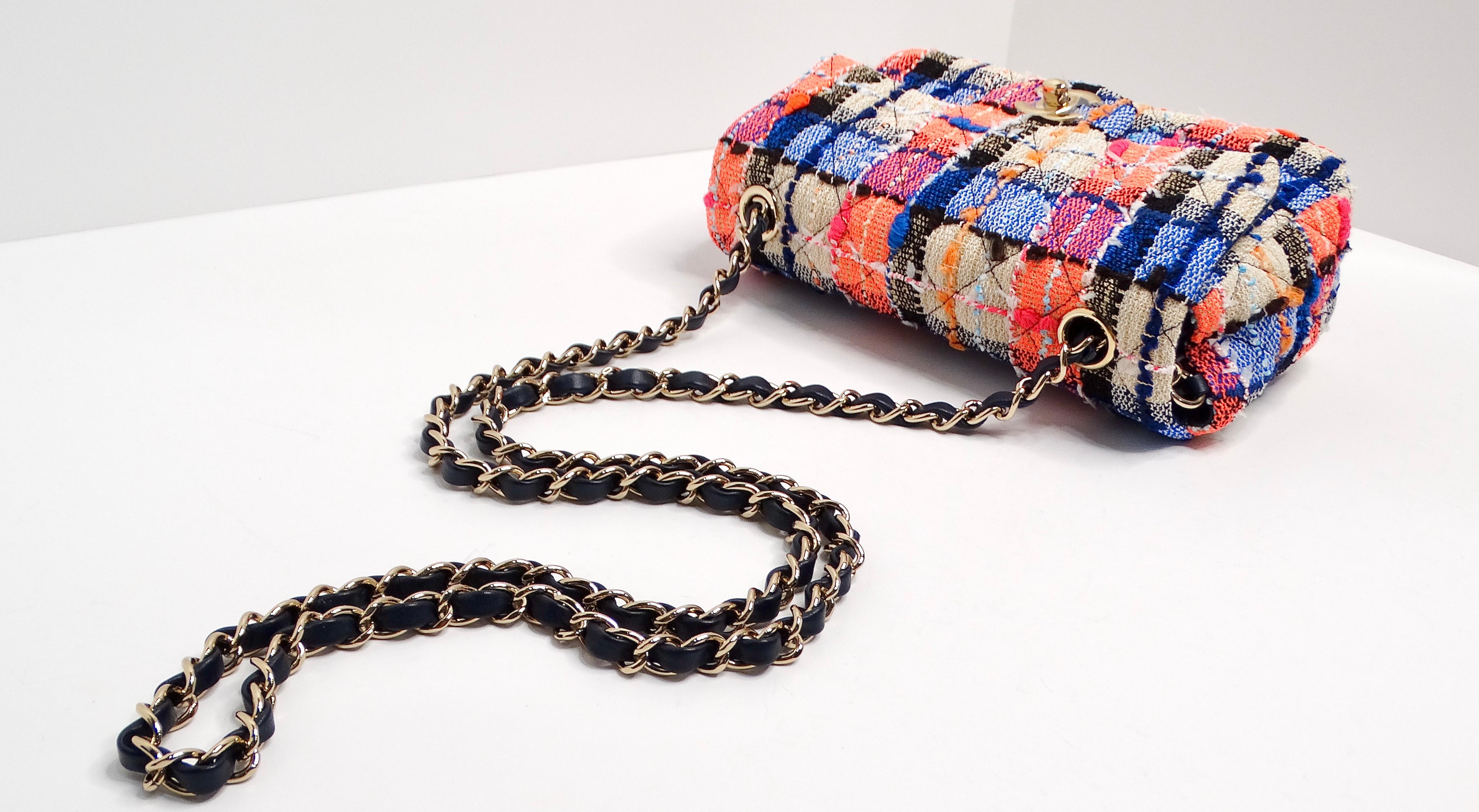 The Chanel Mini Rectangular Tweed Flap Bag in blue, orange, and pink is a vibrant take on the classic flap bag, showcasing Chanel’s signature elegance with a playful twist. Crafted from multicolored tweed, this bag offers a textured and visually